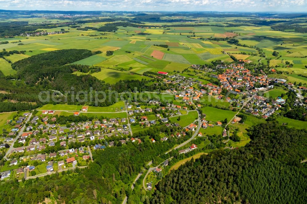 Vöhl from the bird's eye view: Agricultural land and field borders surround the settlement area of the village in Voehl in the state Hesse, Germany