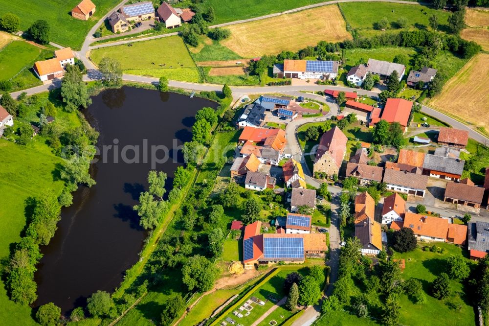 Aerial image Volkhardinghausen - Agricultural land and field borders surround the settlement area of the village in Volkhardinghausen in the state Hesse, Germany