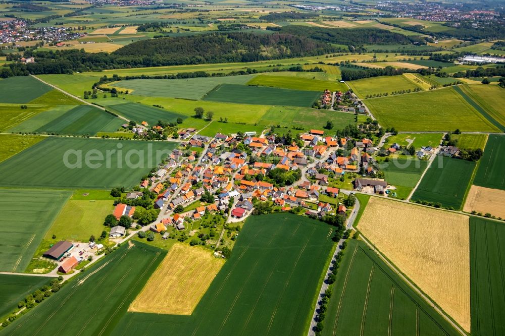 Wethen from above - Agricultural land and field borders surround the settlement area of the village in Wethen in the state Hesse, Germany