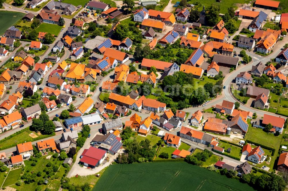 Wethen from the bird's eye view: Agricultural land and field borders surround the settlement area of the village in Wethen in the state Hesse, Germany