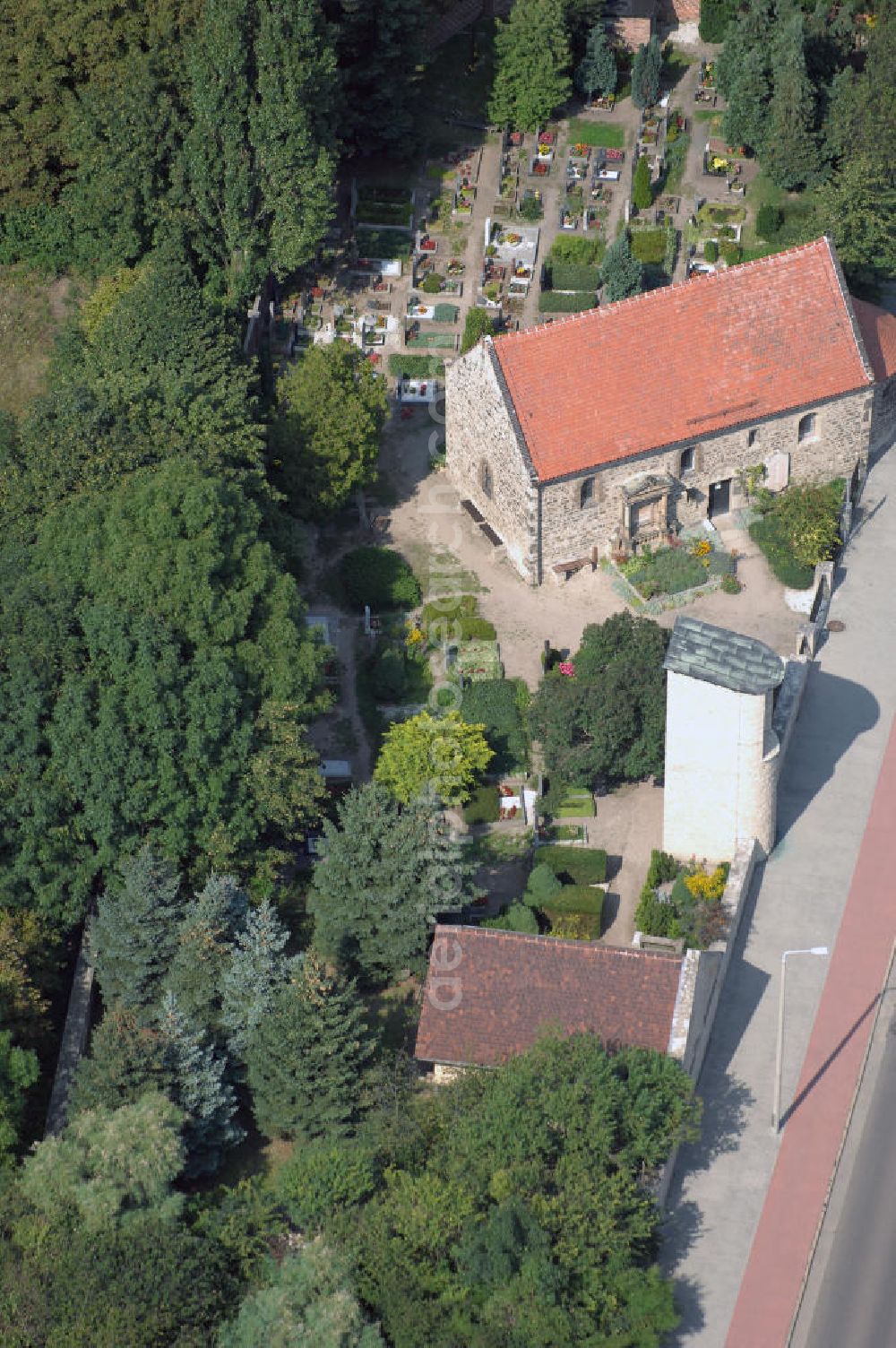 Halle (Saale) from above - Strasse der Romanik: Diese romanische Saalkirche mit Apsis steht in Böllberg, als Beispiel der herben und schlichten Dorfkirchen jener Zeit. Der Bruchsteinbau ist ungewöhnlich gut erhalten, die Nordseite besitzt noch ihre ursprüngliche Gestalt mit den kleinen hoch liegenden Fenstern.