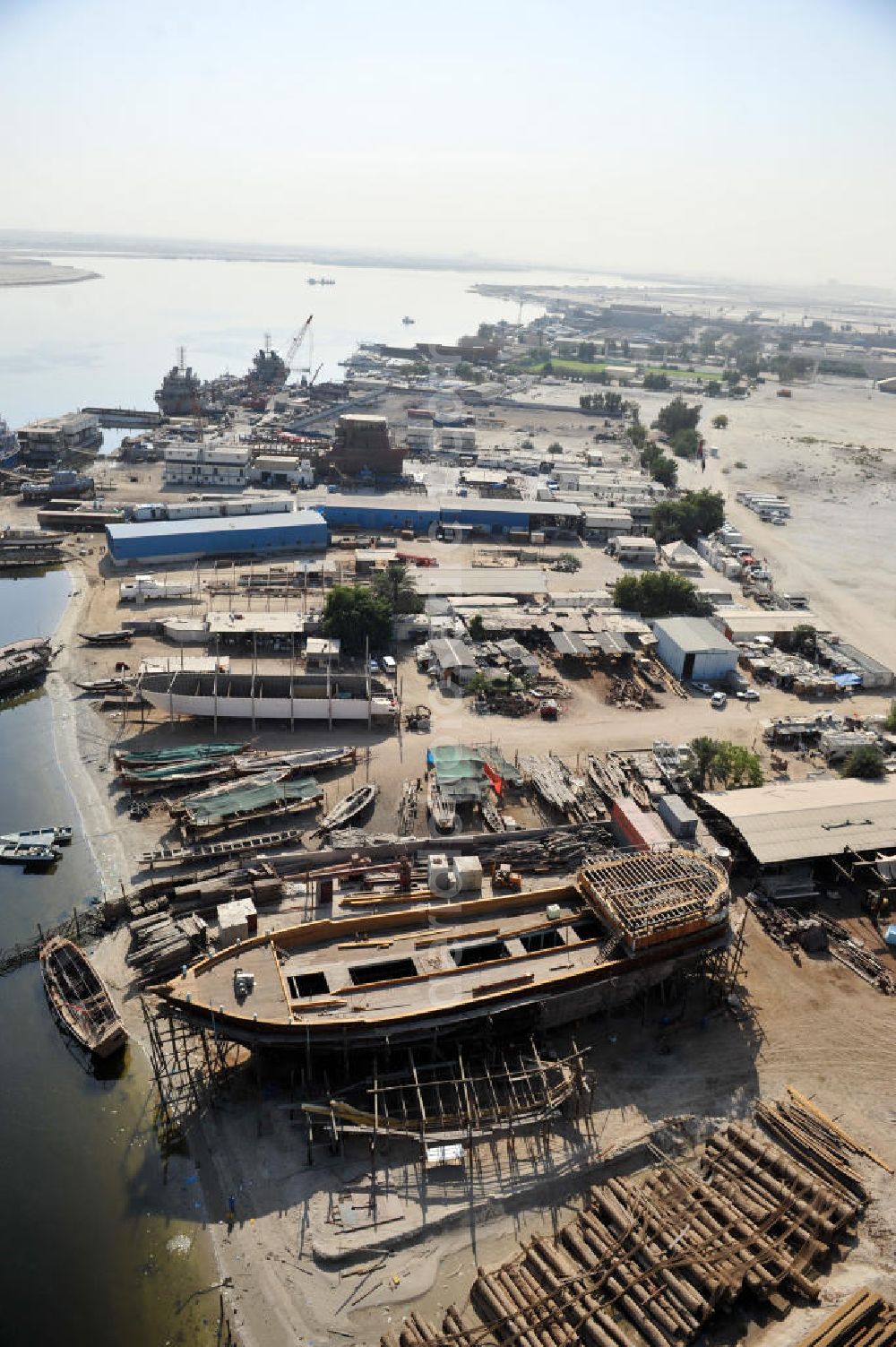 Aerial image Dubai - Überblick auf die Werften Drydocks World in Dubai mit der Werft der Firma GMMOS im hinteren Teil des Bildes und der Werft der traditionellen Holzschiffbaufirma Saif Mohd. Al Qaizi im Vordergrund. GMMOS beschafft u.a. Arbeitsgeräte für die Öl- und Gasindustry im Mittleren Osten und der Golfregion. Die Drydocks sind das größten Trockedocks im Persichen Golf. Overview of the Drydocks World in Dubai. They consist mainly of the dockyards of GMMOS (in the background) and the manufecterers of wooden ships Saif Mohd. Al Qaiz (in the foreground. GMMOS provides equipment to the oil and gas industry in the Middel East and Gulf region. The Drydocks are the only large drydocks facility in the Persian Gulf.