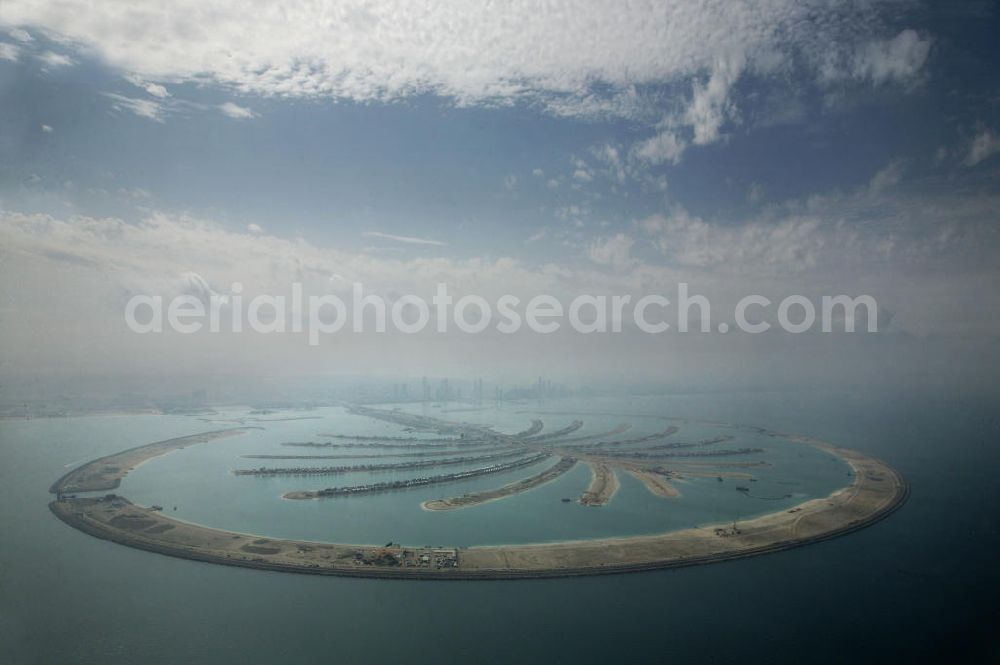 Aerial image Dubai - Die künstliche Insel Palm Jumeirah. Die beiden Inseln The Palm, Jumeirah und The Palm, Jebel Ali, zusammen Palm Islands, sind zwei künstliche Inseln, die vor Dubai im Persischen Golf angelegt wurden. Die Inseln bestehen aus rund 100 Millionen Kubikmeter Fels und durch ein spezielles Rüttelverfahren verdichtetem Sand und sind in Form einer Palme angelegt. Allein die 560 Hektar große Insel The Palm, Jumeirah wird die Küstenlinie Dubais um ca. 100 km verlängern. Bauherr ist die staatseigene Entwicklungs- und Baugesellschaft Nakheel. Die Erdbauarbeiten führen die niederländischen Firmen Royal Boskalis Westminster und Van Oord aus. Die Arbeiten an der Insel Palm Jumeirah wurden 2001 begonnen, im Dezember 2006 waren die ersten Apartements bezugsfertig. Neben Apartementhäusern gibt es auf der Insel Vergnügungsparks, Luxushotels, Einkaufszentren, etc. Die Palm Islands sollen durch eine dritte Insel, Palm Deira, ergänzt werden, die die beiden bestehenden Inseln vom Ausmaß her weit übertreffen wird. / AE, United Arab Emirates, Dubai: Palm Jumeirah. Palm Jumeirah and Palm Jebel Ali are two artificial island with hotels, real estates, shops and large beaches for tourism. Kontakt Nakheel: P.O. Box 17777, Dubai, United Arab Ermirates, Tel. +971 4390333 Fax +971 43903314, Email: info@nakheel.com; Kontakt Royal Boskalis Westminster: Tel. +31(0)79 6969000 Fax +31(0)78 6969555, Email: info@hoskalis.nl; Kontakt Van Oord: Tel. +31(0)10 4478444, Fax +31(0)10 4478100, Email: info@vanoord.com.