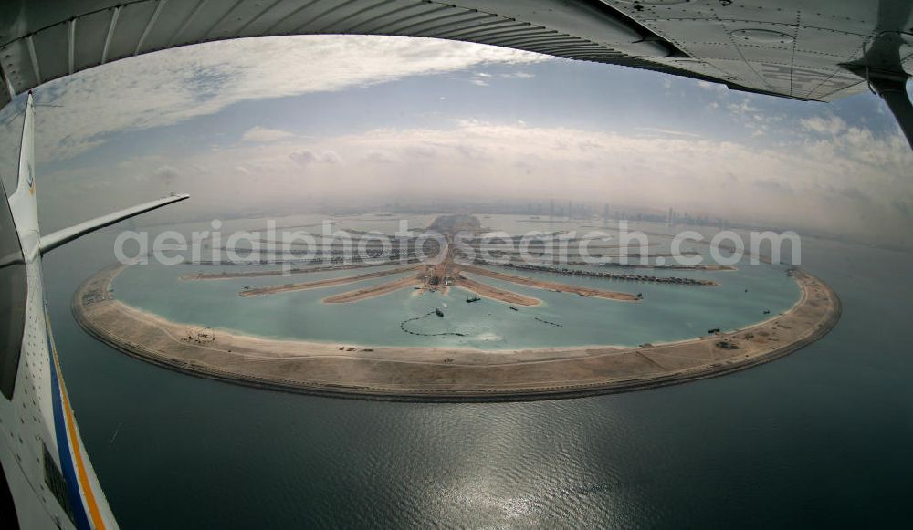 Aerial photograph Dubai - Die künstliche Insel Palm Jumeirah. Die beiden Inseln The Palm, Jumeirah und The Palm, Jebel Ali, zusammen Palm Islands, sind zwei künstliche Inseln, die vor Dubai im Persischen Golf angelegt wurden. Die Inseln bestehen aus rund 100 Millionen Kubikmeter Fels und durch ein spezielles Rüttelverfahren verdichtetem Sand und sind in Form einer Palme angelegt. Allein die 560 Hektar große Insel The Palm, Jumeirah wird die Küstenlinie Dubais um ca. 100 km verlängern. Bauherr ist die staatseigene Entwicklungs- und Baugesellschaft Nakheel. Die Erdbauarbeiten führen die niederländischen Firmen Royal Boskalis Westminster und Van Oord aus. Die Arbeiten an der Insel Palm Jumeirah wurden 2001 begonnen, im Dezember 2006 waren die ersten Apartements bezugsfertig. Neben Apartementhäusern gibt es auf der Insel Vergnügungsparks, Luxushotels, Einkaufszentren, etc. Die Palm Islands sollen durch eine dritte Insel, Palm Deira, ergänzt werden, die die beiden bestehenden Inseln vom Ausmaß her weit übertreffen wird. / AE, United Arab Emirates, Dubai: Palm Jumeirah. Palm Jumeirah and Palm Jebel Ali are two artificial island with hotels, real estates, shops and large beaches for tourism. Kontakt Nakheel: P.O. Box 17777, Dubai, United Arab Ermirates, Tel. +971 4390333 Fax +971 43903314, Email: info@nakheel.com; Kontakt Royal Boskalis Westminster: Tel. +31(0)79 6969000 Fax +31(0)78 6969555, Email: info@hoskalis.nl; Kontakt Van Oord: Tel. +31(0)10 4478444, Fax +31(0)10 4478100, Email: info@vanoord.com.