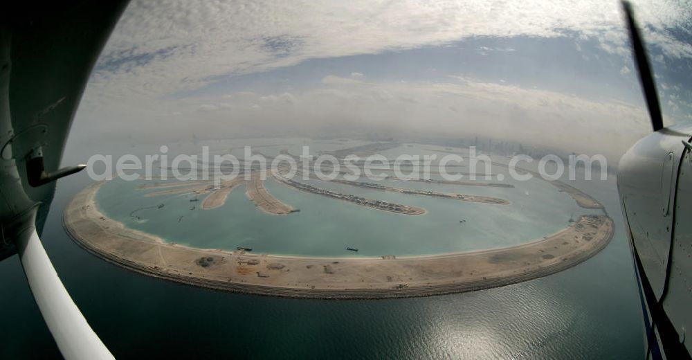 Dubai from above - Die künstliche Insel Palm Jumeirah. Die beiden Inseln The Palm, Jumeirah und The Palm, Jebel Ali, zusammen Palm Islands, sind zwei künstliche Inseln, die vor Dubai im Persischen Golf angelegt wurden. Die Inseln bestehen aus rund 100 Millionen Kubikmeter Fels und durch ein spezielles Rüttelverfahren verdichtetem Sand und sind in Form einer Palme angelegt. Allein die 560 Hektar große Insel The Palm, Jumeirah wird die Küstenlinie Dubais um ca. 100 km verlängern. Bauherr ist die staatseigene Entwicklungs- und Baugesellschaft Nakheel. Die Erdbauarbeiten führen die niederländischen Firmen Royal Boskalis Westminster und Van Oord aus. Die Arbeiten an der Insel Palm Jumeirah wurden 2001 begonnen, im Dezember 2006 waren die ersten Apartements bezugsfertig. Neben Apartementhäusern gibt es auf der Insel Vergnügungsparks, Luxushotels, Einkaufszentren, etc. Die Palm Islands sollen durch eine dritte Insel, Palm Deira, ergänzt werden, die die beiden bestehenden Inseln vom Ausmaß her weit übertreffen wird. / AE, United Arab Emirates, Dubai: Palm Jumeirah. Palm Jumeirah and Palm Jebel Ali are two artificial island with hotels, real estates, shops and large beaches for tourism. Kontakt Nakheel: P.O. Box 17777, Dubai, United Arab Ermirates, Tel. +971 4390333 Fax +971 43903314, Email: info@nakheel.com; Kontakt Royal Boskalis Westminster: Tel. +31(0)79 6969000 Fax +31(0)78 6969555, Email: info@hoskalis.nl; Kontakt Van Oord: Tel. +31(0)10 4478444, Fax +31(0)10 4478100, Email: info@vanoord.com.