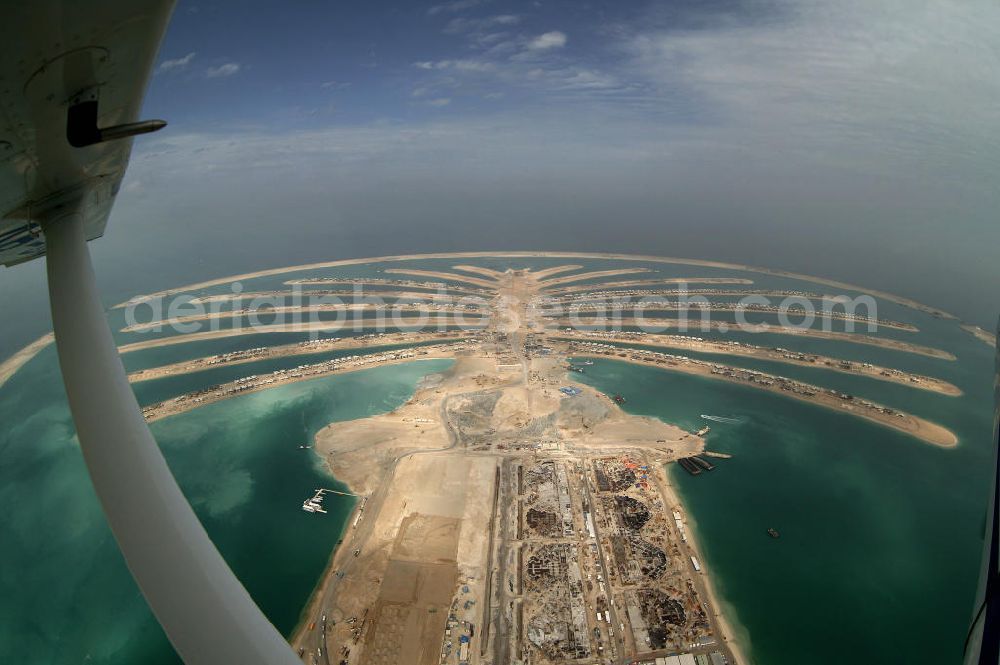 Aerial image Dubai - Die künstliche Insel Palm Jumeirah. Die beiden Inseln The Palm, Jumeirah und The Palm, Jebel Ali, zusammen Palm Islands, sind zwei künstliche Inseln, die vor Dubai im Persischen Golf angelegt wurden. Die Inseln bestehen aus rund 100 Millionen Kubikmeter Fels und durch ein spezielles Rüttelverfahren verdichtetem Sand und sind in Form einer Palme angelegt. Allein die 560 Hektar große Insel The Palm, Jumeirah wird die Küstenlinie Dubais um ca. 100 km verlängern. Bauherr ist die staatseigene Entwicklungs- und Baugesellschaft Nakheel. Die Erdbauarbeiten führen die niederländischen Firmen Royal Boskalis Westminster und Van Oord aus. Die Arbeiten an der Insel Palm Jumeirah wurden 2001 begonnen, im Dezember 2006 waren die ersten Apartements bezugsfertig. Neben Apartementhäusern gibt es auf der Insel Vergnügungsparks, Luxushotels, Einkaufszentren, etc. Die Palm Islands sollen durch eine dritte Insel, Palm Deira, ergänzt werden, die die beiden bestehenden Inseln vom Ausmaß her weit übertreffen wird. / AE, United Arab Emirates, Dubai: Palm Jumeirah. Palm Jumeirah and Palm Jebel Ali are two artificial island with hotels, real estates, shops and large beaches for tourism. Kontakt Nakheel: P.O. Box 17777, Dubai, United Arab Ermirates, Tel. +971 4390333 Fax +971 43903314, Email: info@nakheel.com; Kontakt Royal Boskalis Westminster: Tel. +31(0)79 6969000 Fax +31(0)78 6969555, Email: info@hoskalis.nl; Kontakt Van Oord: Tel. +31(0)10 4478444, Fax +31(0)10 4478100, Email: info@vanoord.com.