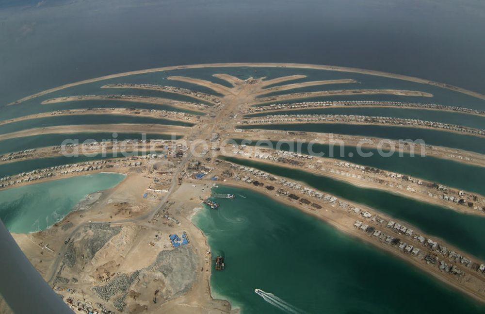 Aerial photograph Dubai - Die künstliche Insel Palm Jumeirah. Die beiden Inseln The Palm, Jumeirah und The Palm, Jebel Ali, zusammen Palm Islands, sind zwei künstliche Inseln, die vor Dubai im Persischen Golf angelegt wurden. Die Inseln bestehen aus rund 100 Millionen Kubikmeter Fels und durch ein spezielles Rüttelverfahren verdichtetem Sand und sind in Form einer Palme angelegt. Allein die 560 Hektar große Insel The Palm, Jumeirah wird die Küstenlinie Dubais um ca. 100 km verlängern. Bauherr ist die staatseigene Entwicklungs- und Baugesellschaft Nakheel. Die Erdbauarbeiten führen die niederländischen Firmen Royal Boskalis Westminster und Van Oord aus. Die Arbeiten an der Insel Palm Jumeirah wurden 2001 begonnen, im Dezember 2006 waren die ersten Apartements bezugsfertig. Neben Apartementhäusern gibt es auf der Insel Vergnügungsparks, Luxushotels, Einkaufszentren, etc. Die Palm Islands sollen durch eine dritte Insel, Palm Deira, ergänzt werden, die die beiden bestehenden Inseln vom Ausmaß her weit übertreffen wird. / AE, United Arab Emirates, Dubai: Palm Jumeirah. Palm Jumeirah and Palm Jebel Ali are two artificial island with hotels, real estates, shops and large beaches for tourism. Kontakt Nakheel: P.O. Box 17777, Dubai, United Arab Ermirates, Tel. +971 4390333 Fax +971 43903314, Email: info@nakheel.com; Kontakt Royal Boskalis Westminster: Tel. +31(0)79 6969000 Fax +31(0)78 6969555, Email: info@hoskalis.nl; Kontakt Van Oord: Tel. +31(0)10 4478444, Fax +31(0)10 4478100, Email: info@vanoord.com.