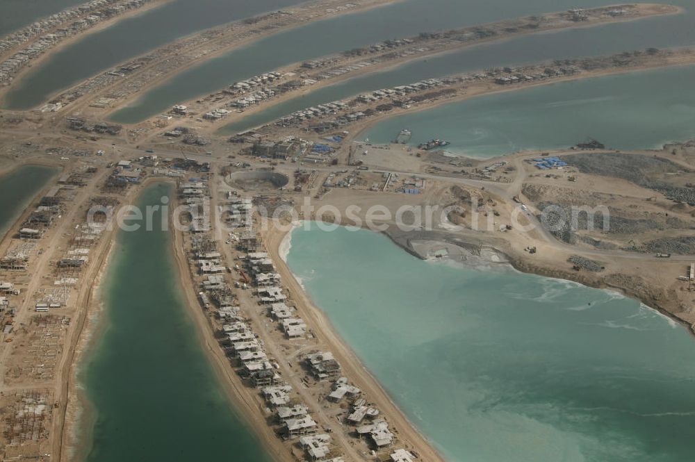 Dubai from above - Die künstliche Insel Palm Jumeirah. Die beiden Inseln The Palm, Jumeirah und The Palm, Jebel Ali, zusammen Palm Islands, sind zwei künstliche Inseln, die vor Dubai im Persischen Golf angelegt wurden. Die Inseln bestehen aus rund 100 Millionen Kubikmeter Fels und durch ein spezielles Rüttelverfahren verdichtetem Sand und sind in Form einer Palme angelegt. Allein die 560 Hektar große Insel The Palm, Jumeirah wird die Küstenlinie Dubais um ca. 100 km verlängern. Bauherr ist die staatseigene Entwicklungs- und Baugesellschaft Nakheel. Die Erdbauarbeiten führen die niederländischen Firmen Royal Boskalis Westminster und Van Oord aus. Die Arbeiten an der Insel Palm Jumeirah wurden 2001 begonnen, im Dezember 2006 waren die ersten Apartements bezugsfertig. Neben Apartementhäusern gibt es auf der Insel Vergnügungsparks, Luxushotels, Einkaufszentren, etc. Die Palm Islands sollen durch eine dritte Insel, Palm Deira, ergänzt werden, die die beiden bestehenden Inseln vom Ausmaß her weit übertreffen wird. / AE, United Arab Emirates, Dubai: Palm Jumeirah. Palm Jumeirah and Palm Jebel Ali are two artificial island with hotels, real estates, shops and large beaches for tourism. Kontakt Nakheel: P.O. Box 17777, Dubai, United Arab Ermirates, Tel. +971 4390333 Fax +971 43903314, Email: info@nakheel.com; Kontakt Royal Boskalis Westminster: Tel. +31(0)79 6969000 Fax +31(0)78 6969555, Email: info@hoskalis.nl; Kontakt Van Oord: Tel. +31(0)10 4478444, Fax +31(0)10 4478100, Email: info@vanoord.com.