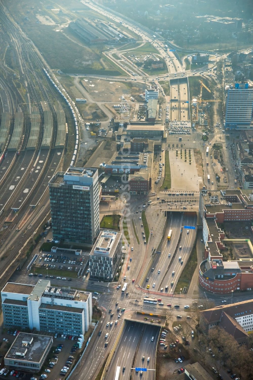 Duisburg from above - Bahnhofsplatte square, federal motorway A59 and main station of Duisburg in the state of North Rhine-Westphalia. The square covers the tunnel of A59. Business and office buildings are standing along the road