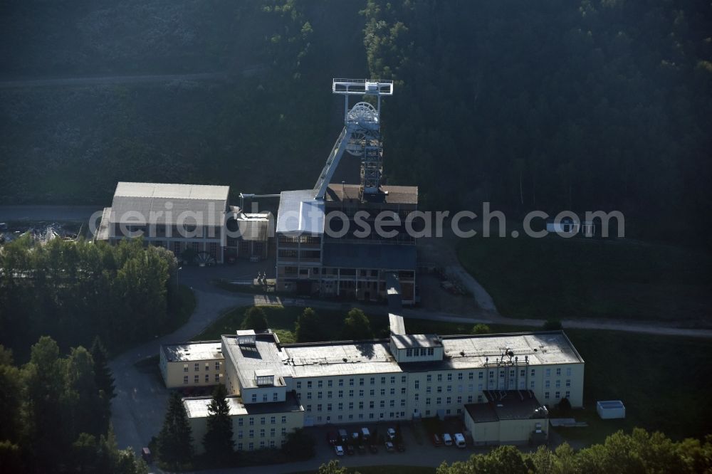 Hartenstein from the bird's eye view: Former headframe and mining pit Schacht 371 of SDAG Wismut in the Poppenwald forest in the borough of Hartenstein in the state of Saxony. The pit was the main pit of the now disused mining company of Aue and is used as a museum of the mineral collection of Wismut GmbH