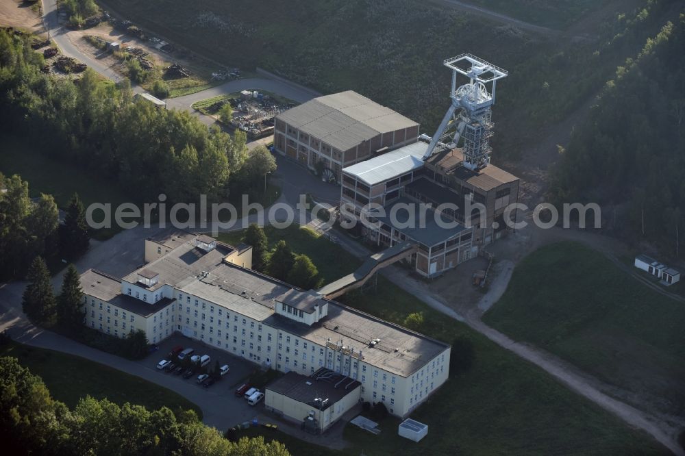 Hartenstein from the bird's eye view: Former headframe and mining pit Schacht 371 of SDAG Wismut in the Poppenwald forest in the borough of Hartenstein in the state of Saxony. The pit was the main pit of the now disused mining company of Aue and is used as a museum of the mineral collection of Wismut GmbH