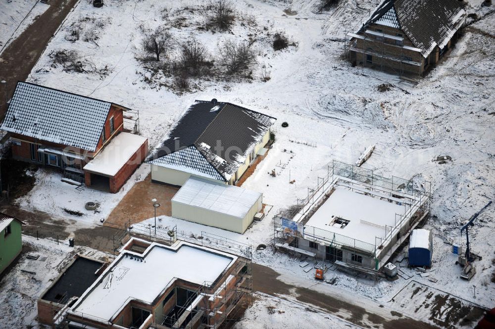 Aerial photograph Magdeburg - Blick auf das winterlich verschneite Einfamilien- Wohnneubaugebiet Am Birnengarten in Magdeburg-Ottersleben, mit Erweiterungsflächen und verschiedenen Baustellen.