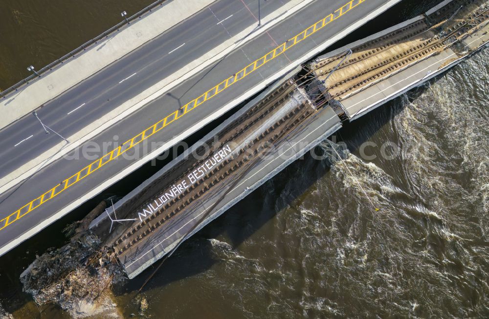 Aerial image Dresden - Concrete segments fallen into the riverbed of the Elbe with the slogan Tax millionaires of the collapsed river bridge structure for crossing the Elbe Carolabruecke on the street Carolabruecke in Dresden in the federal state of Saxony, Germany