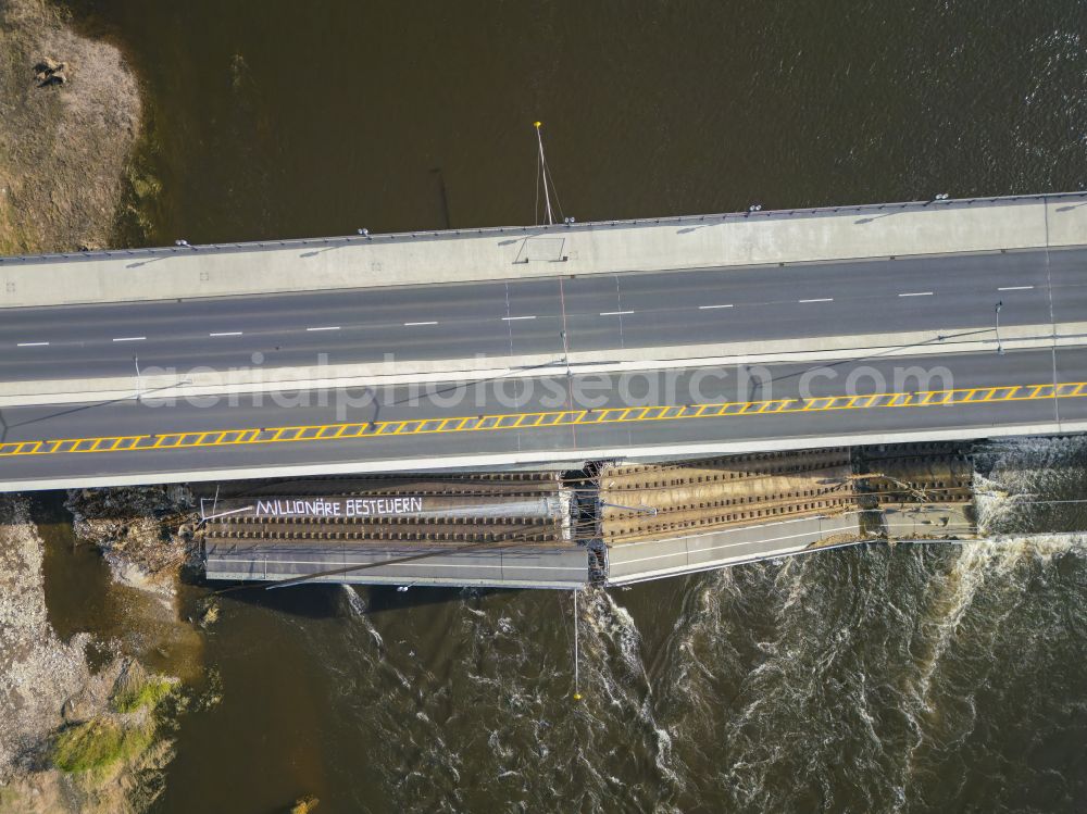 Aerial photograph Dresden - Concrete segments fallen into the riverbed of the Elbe with the slogan Tax millionaires of the collapsed river bridge structure for crossing the Elbe Carolabruecke on the street Carolabruecke in Dresden in the federal state of Saxony, Germany