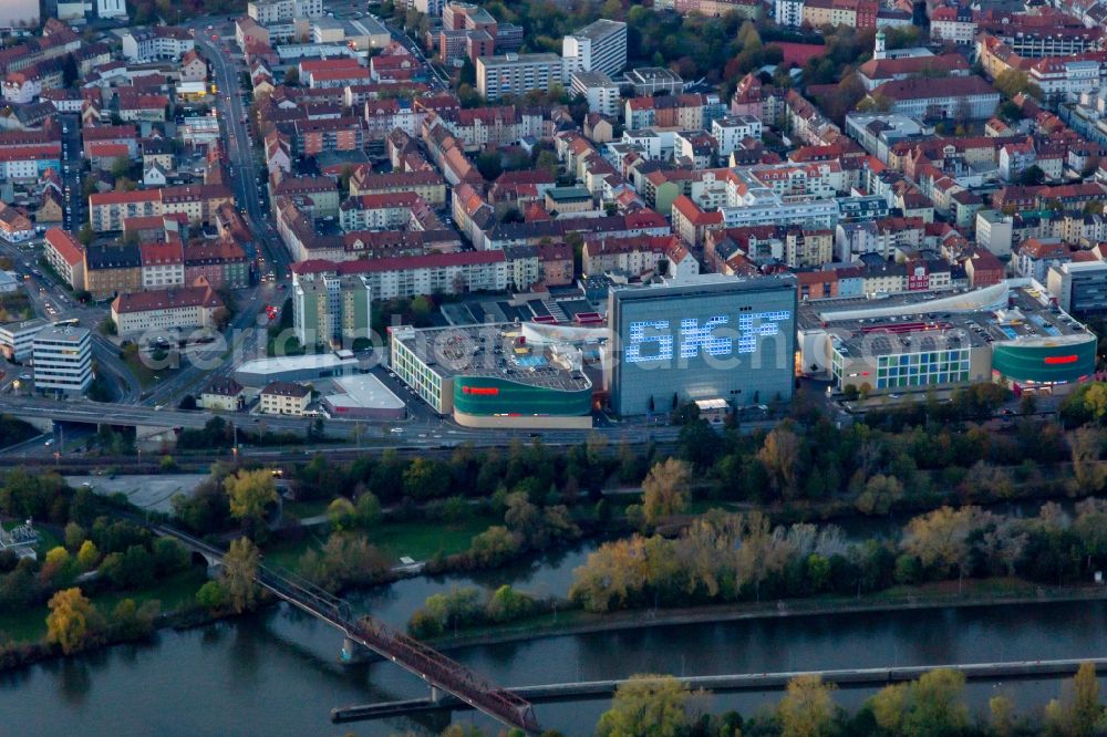 Schweinfurt from the bird's eye view: Building of the shopping center Stadtgalerie Schweinfurt and illumated SKF Hochhaus at dusk in Schweinfurt in the state Bavaria, Germany