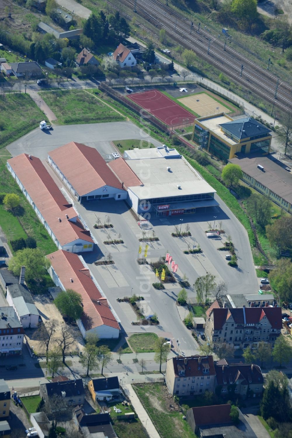 Falkensee from the bird's eye view: Rewe and Aldi shopping centers on Bahnhofstrasse in Falkensee in Brandenburg