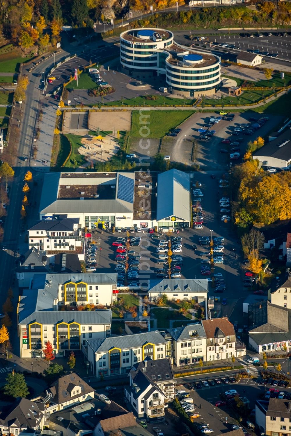 Attendorn from the bird's eye view: Shopping center and HANSE HOTEL in Attendorn in the state of North Rhine-Westphalia. The architectural distinct hotel with its round buildings is located in the background