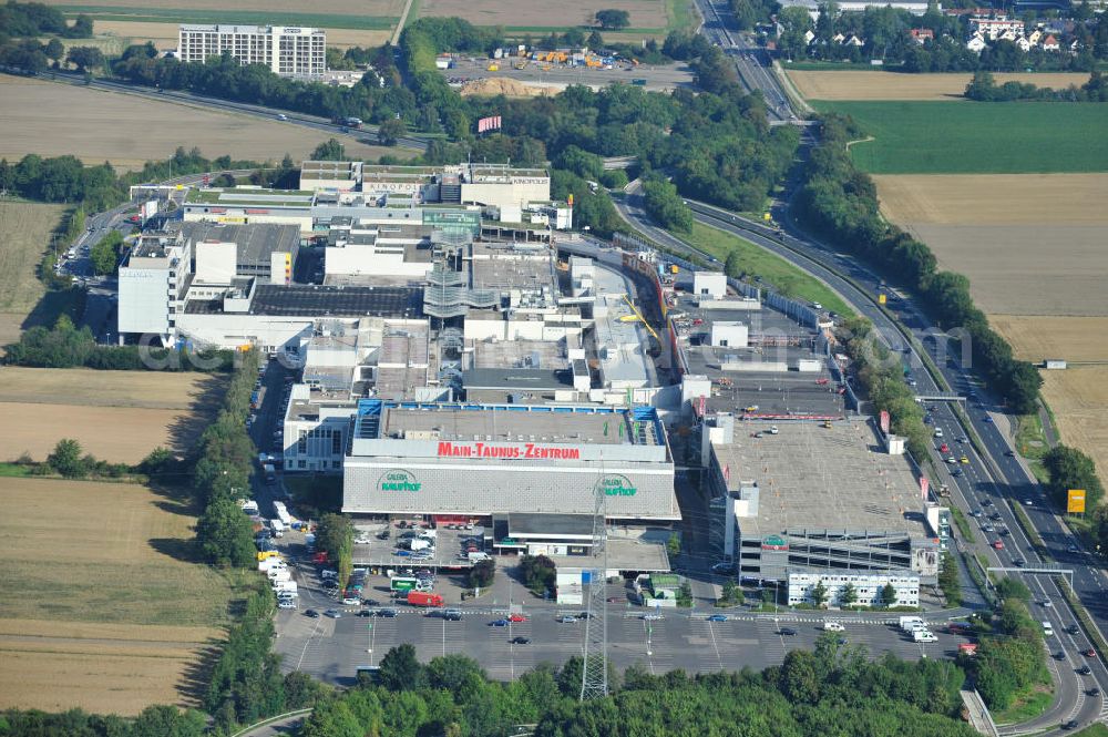 Aerial photograph Sulzbach - Blick auf das Einkaufszentrum MTZ Main-Taunus-Zentrum in Sulzbach / Hessen. Das Einzelhandelszentrum ist mit dem Eröffnungsjahr 1964 das älteste Einkaufszentrum der heute europaweit agierenden ECE Projektmanagement GmbH und der Prototyp des Einkaufszentrums. Das MTZ wurde umfassend modernisiert und erweitert und ist heute Hessens größtes Zentrum. Shopping center MTZ Main-Taunus - Center in Sulzbach / Hesse.