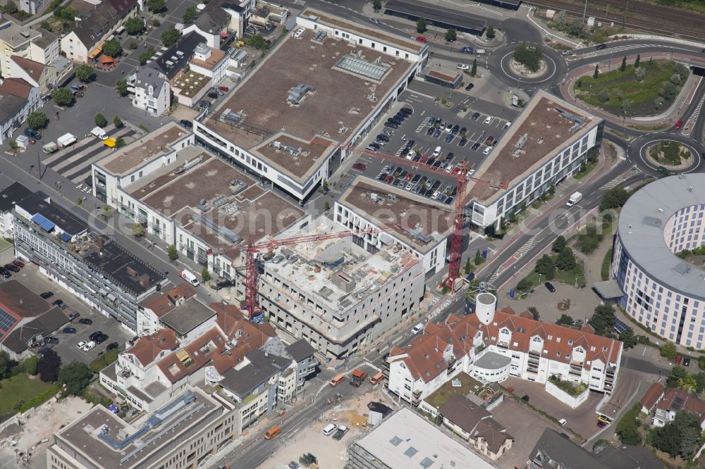 Aerial photograph Ingelheim am Rhein - The shopping center Neue Mitte Ingelheim in Ingelheim am Rhein in Rhineland-Palatinate. The center was built by the construction company Ingelheimer Gemuenden towards the circular building of the city administration. In front of that: the construction site of a hotel