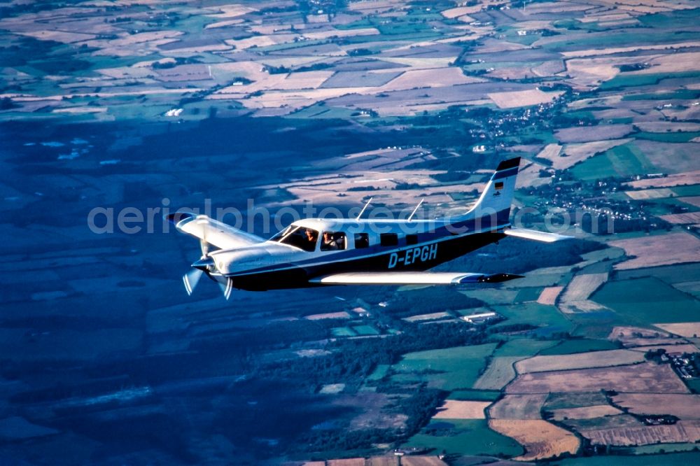 Wallsbüll from the bird's eye view: Single-engine business aircraft in the airspace in Wallsbuell in the state of Schleswig-Holstein