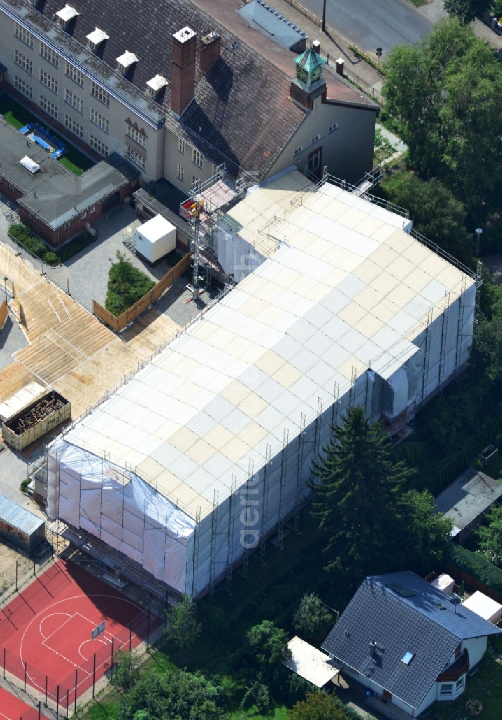 Aerial photograph Berlin Kaulsdorf - Renovation work on the roof of the sports hall of the primary school at the ulmenstrasse in Kaulsdorf in Berlin