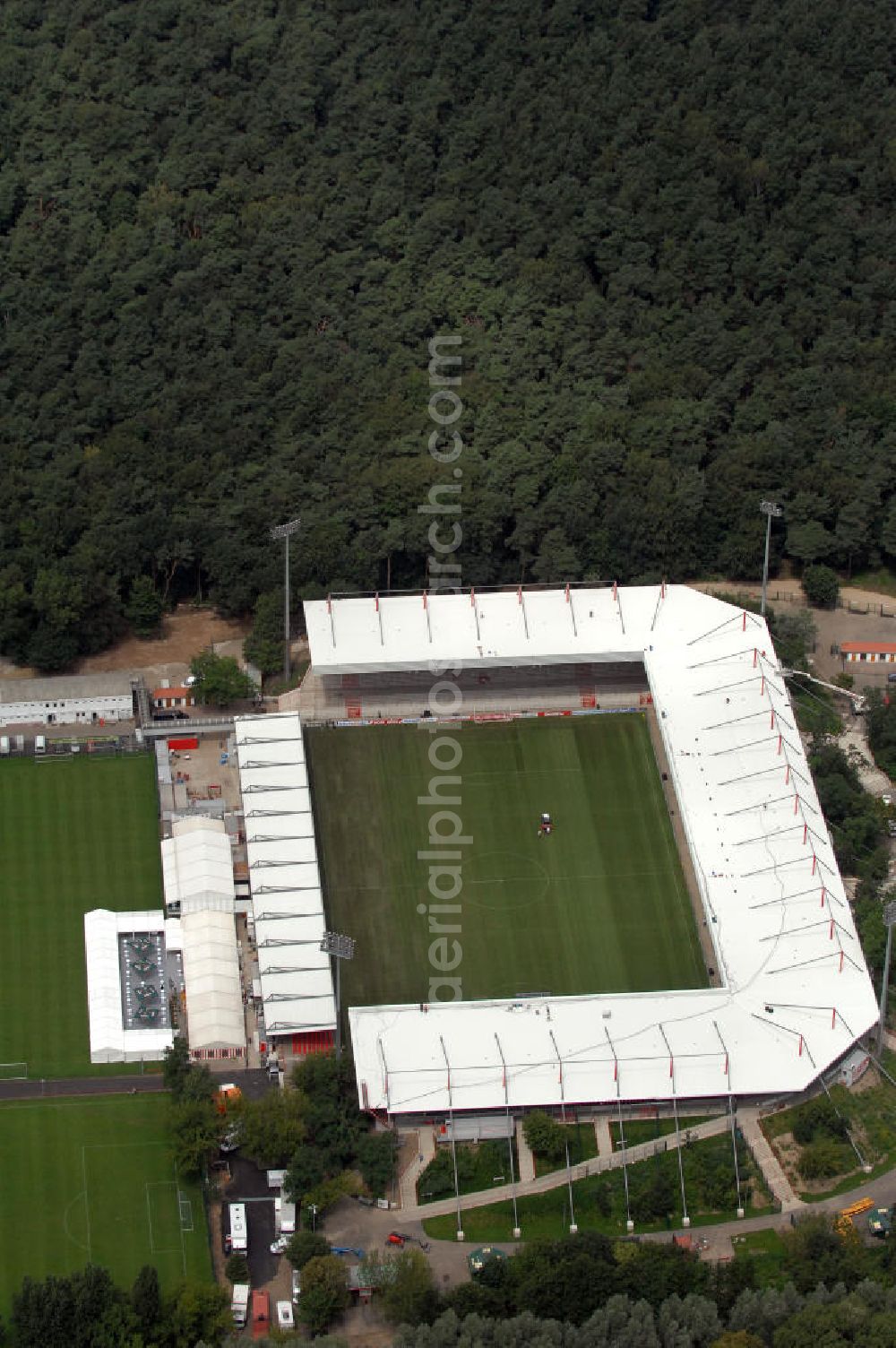 Aerial image Berlin - Blick auf das nach dem Umbau fertiggestellte Stadion Alte Försterei in Berlin-Köpenick am Tag der Einweihung. Es ist die Heimspielstätte des 1. FC Union Berlin. Das Stadion sowie die umliegenden Sportstätten werden im Norden durch den Volkspark Wuhlheide, im Osten durch die Hämmerlingstraße, im Süden durch die Wuhle (die an dieser Stelle in die Spree mündet) und im Westen durch die Straße An der Wuhlheide begrenzt. Insgesamt umfasst das Areal neben dem Fußballstadion noch eine Kegelhalle, zwei Ballspielhallen (welche seit dem Frühjahr 2008 saniert werden) sowie sechs weitere Trainingsplätze. Das Fußballstadion ist mit einem Fassungsvermögen von 18.100 Zuschauern (davon 16.600 Steh- und 1.500 überdachte Sitzplätze) das größte reine Fußballstadion Berlins. Kontakt: 1. FC Union Berlin e.V., An der Wuhlheide 263, 12555 Berlin, Tel. 030 656688 0, Fax 030 656688 99, email: verein@fc-union-berlin.de