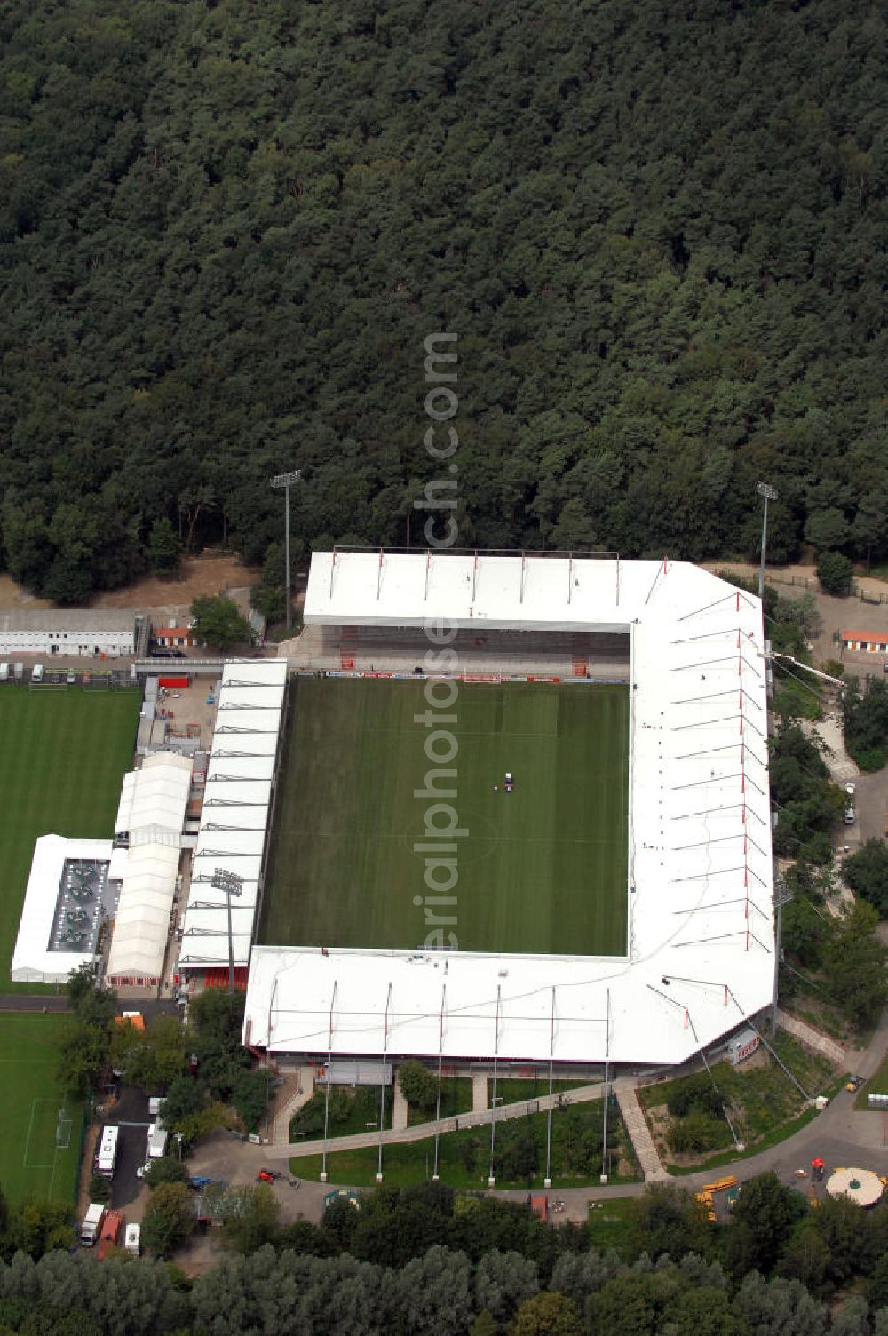 Aerial photograph Berlin - Blick auf das nach dem Umbau fertiggestellte Stadion Alte Försterei in Berlin-Köpenick am Tag der Einweihung. Es ist die Heimspielstätte des 1. FC Union Berlin. Das Stadion sowie die umliegenden Sportstätten werden im Norden durch den Volkspark Wuhlheide, im Osten durch die Hämmerlingstraße, im Süden durch die Wuhle (die an dieser Stelle in die Spree mündet) und im Westen durch die Straße An der Wuhlheide begrenzt. Insgesamt umfasst das Areal neben dem Fußballstadion noch eine Kegelhalle, zwei Ballspielhallen (welche seit dem Frühjahr 2008 saniert werden) sowie sechs weitere Trainingsplätze. Das Fußballstadion ist mit einem Fassungsvermögen von 18.100 Zuschauern (davon 16.600 Steh- und 1.500 überdachte Sitzplätze) das größte reine Fußballstadion Berlins. Kontakt: 1. FC Union Berlin e.V., An der Wuhlheide 263, 12555 Berlin, Tel. 030 656688 0, Fax 030 656688 99, email: verein@fc-union-berlin.de