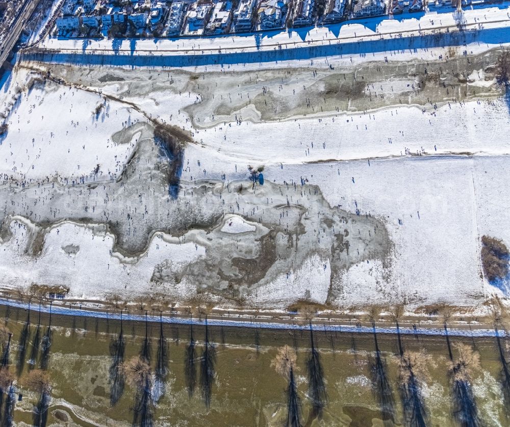 Düsseldorf from the bird's eye view: Walkers and passers-by walk on the ice sheet of the frozen bank areas in the course of the river of the Rhine river in the district Niederkassel in Duesseldorf in the state North Rhine-Westphalia, Germany