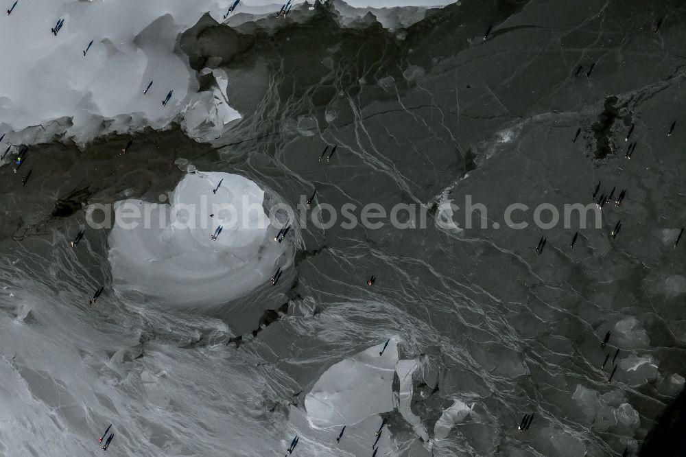 Münster from the bird's eye view: strollers and passers-by walk on the ice sheet of the frozen bank areas of the lake - surface of Aasee in the district Pluggendorf in Muenster in the state North Rhine-Westphalia, Germany