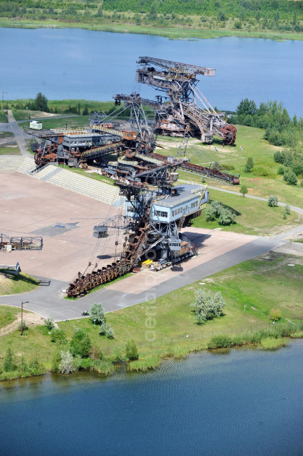 Aerial photograph Gräfenhainichen - Die Eisenstadt Ferropolis entstand aus den Überresten des Braunkohle Tagebaus Golpa-Nord. Der Tagebau wurde geflutet. Einige Braunkohlebagger erinnern an den Tagebau. Heute finden in Ferropolis Festivals, Konzerte und an dere Veranstaltungen statt.Außerdem beherbergt die Halbinsel ein Museum. Ferropolis, called City of Metal. It is situated on the area of the former opencast mining Golpa-Nord. The opencast mining got flooded. Some of the huge excavators are situatet on the area. Today festivals, concerts and other events take place there. There also is a museum.