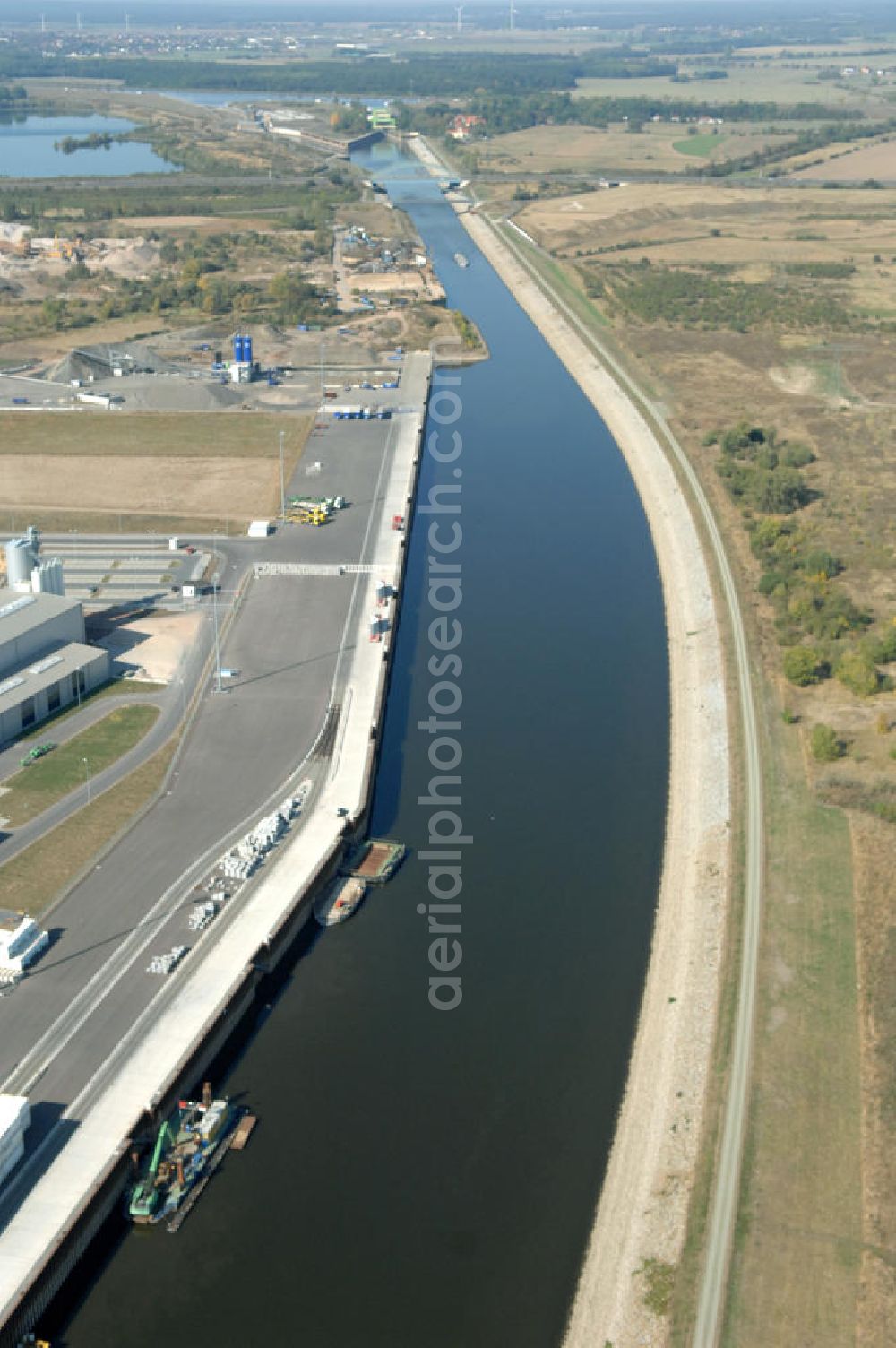 Aerial photograph MAGDEBURG - Blick auf die Industriegebiete am Ufer des Elbe-Abstiegskanal, der den Magdeburger Binnen- Hafen mit der Schleuse Rothensee und dem Mittellandkanal verbindet: Dieser wird auf breiter Front derzeit ausgebaut. Die Bauvorhaben unterstützen die Bestrebungen der Magdeburger Hafengesellschaft, den größten Binnenhafen Mitteldeutschlands zu einer Drehscheibe des internationalen Schiffstransports zu machen. Kontakt WSV: Wasserstraßen-Neubauamt Magdeburg, 39106 Magdeburg, Tel. +49(0)391 535-0, email: wna-magdeburg@wsv.bund.de