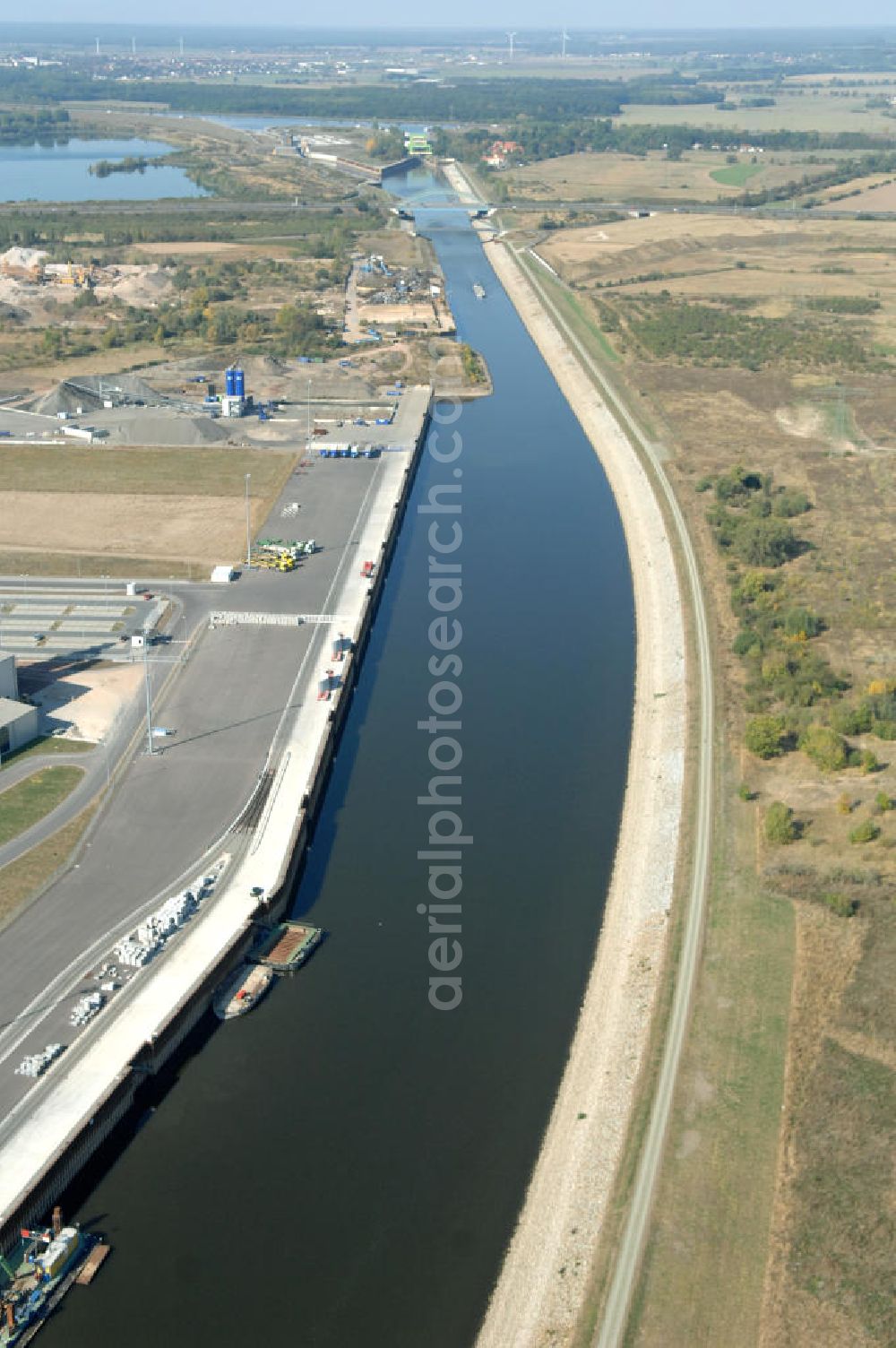 MAGDEBURG from above - Blick auf die Industriegebiete am Ufer des Elbe-Abstiegskanal, der den Magdeburger Binnen- Hafen mit der Schleuse Rothensee und dem Mittellandkanal verbindet: Dieser wird auf breiter Front derzeit ausgebaut. Die Bauvorhaben unterstützen die Bestrebungen der Magdeburger Hafengesellschaft, den größten Binnenhafen Mitteldeutschlands zu einer Drehscheibe des internationalen Schiffstransports zu machen. Kontakt WSV: Wasserstraßen-Neubauamt Magdeburg, 39106 Magdeburg, Tel. +49(0)391 535-0, email: wna-magdeburg@wsv.bund.de