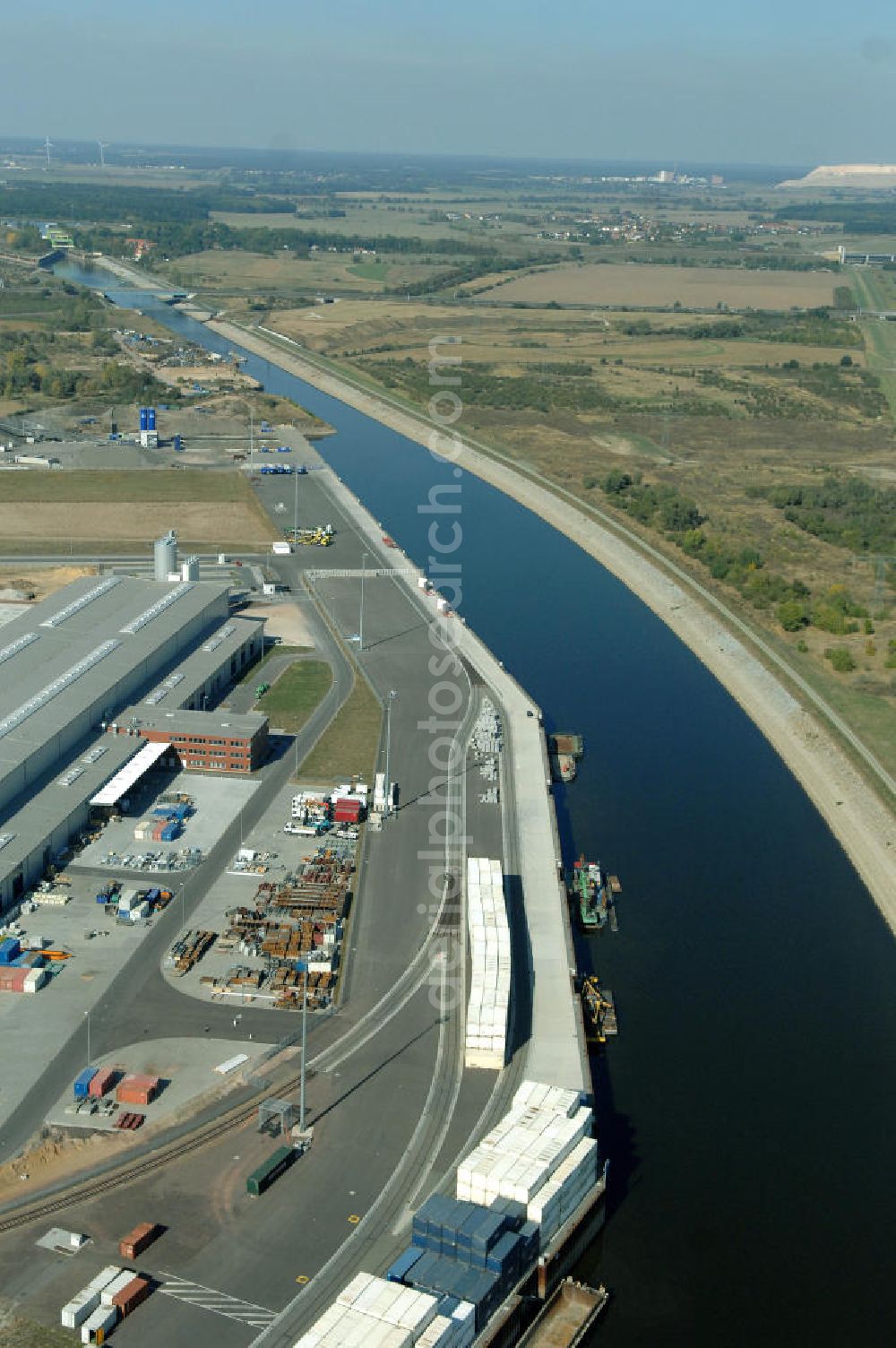 MAGDEBURG from the bird's eye view: Blick auf die Industriegebiete am Ufer des Elbe-Abstiegskanal, der den Magdeburger Binnen- Hafen mit der Schleuse Rothensee und dem Mittellandkanal verbindet: Dieser wird auf breiter Front derzeit ausgebaut. Die Bauvorhaben unterstützen die Bestrebungen der Magdeburger Hafengesellschaft, den größten Binnenhafen Mitteldeutschlands zu einer Drehscheibe des internationalen Schiffstransports zu machen. Kontakt WSV: Wasserstraßen-Neubauamt Magdeburg, 39106 Magdeburg, Tel. +49(0)391 535-0, email: wna-magdeburg@wsv.bund.de