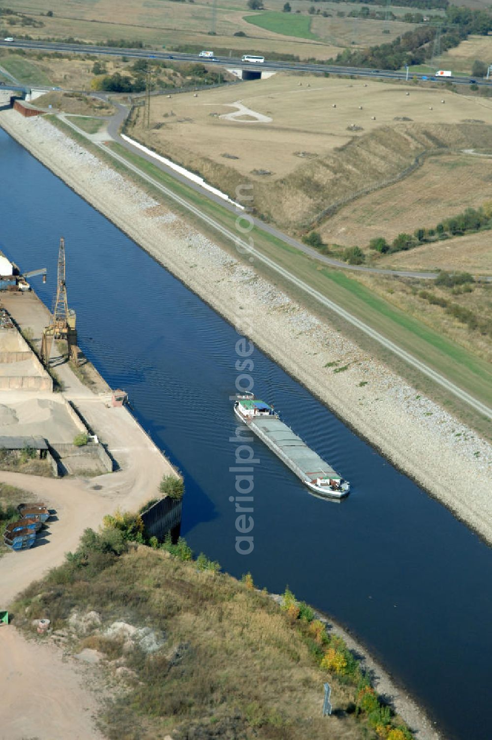 Aerial photograph MAGDEBURG - Blick auf die Industriegebiete am Ufer des Elbe-Abstiegskanal, der den Magdeburger Binnen- Hafen mit der Schleuse Rothensee und dem Mittellandkanal verbindet: Dieser wird auf breiter Front derzeit ausgebaut. Die Bauvorhaben unterstützen die Bestrebungen der Magdeburger Hafengesellschaft, den größten Binnenhafen Mitteldeutschlands zu einer Drehscheibe des internationalen Schiffstransports zu machen. Kontakt WSV: Wasserstraßen-Neubauamt Magdeburg, 39106 Magdeburg, Tel. +49(0)391 535-0, email: wna-magdeburg@wsv.bund.de