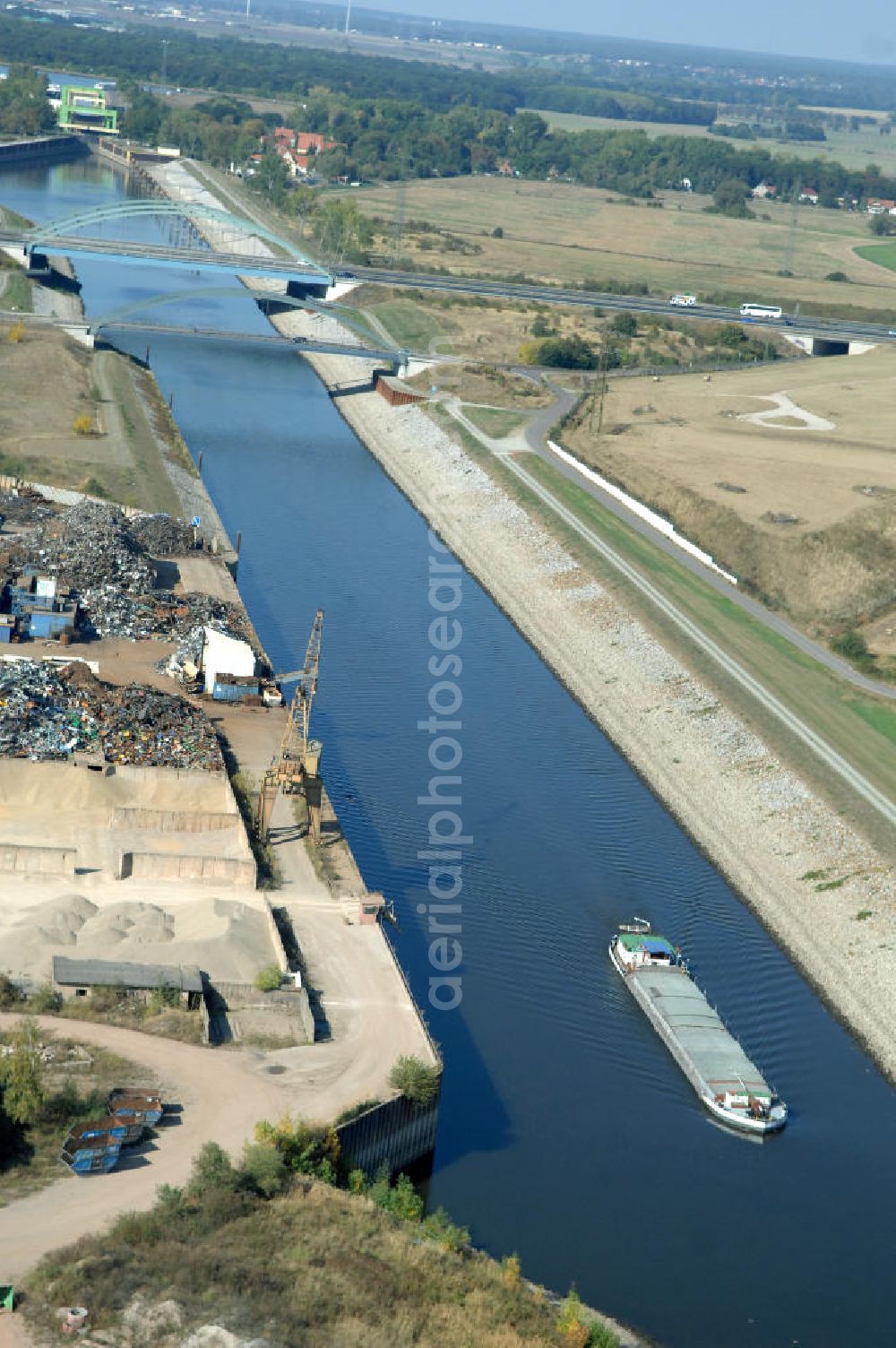 MAGDEBURG from above - Blick auf die Industriegebiete am Ufer des Elbe-Abstiegskanal, der den Magdeburger Binnen- Hafen mit der Schleuse Rothensee und dem Mittellandkanal verbindet: Dieser wird auf breiter Front derzeit ausgebaut. Die Bauvorhaben unterstützen die Bestrebungen der Magdeburger Hafengesellschaft, den größten Binnenhafen Mitteldeutschlands zu einer Drehscheibe des internationalen Schiffstransports zu machen. Kontakt WSV: Wasserstraßen-Neubauamt Magdeburg, 39106 Magdeburg, Tel. +49(0)391 535-0, email: wna-magdeburg@wsv.bund.de