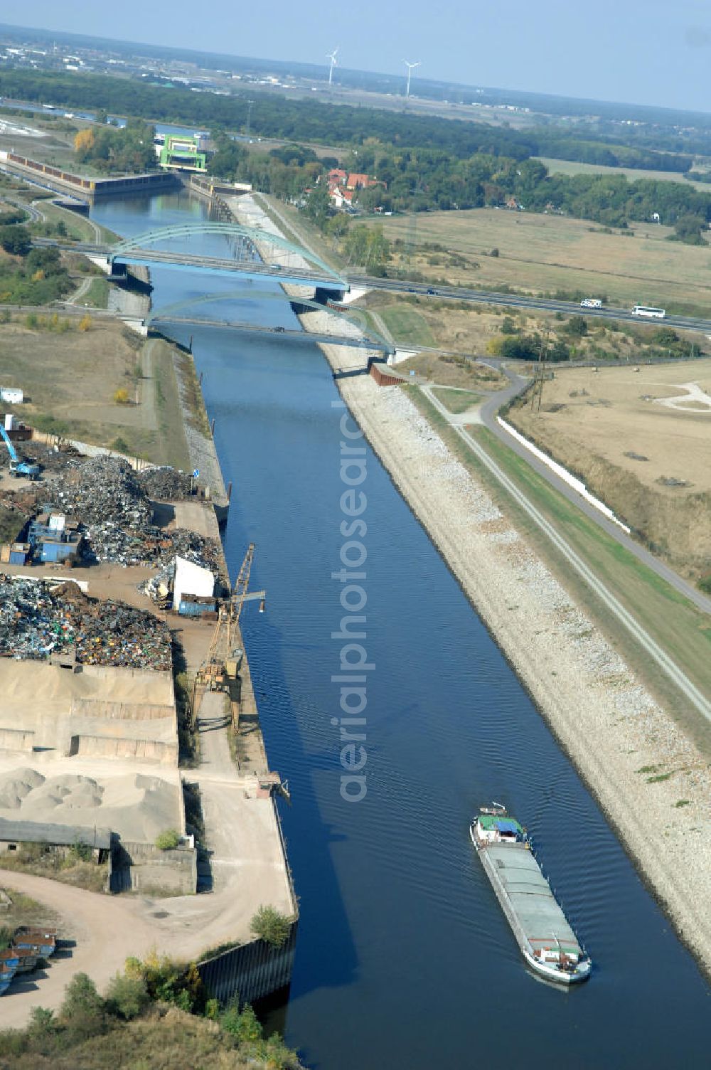 MAGDEBURG from the bird's eye view: Blick auf die Industriegebiete am Ufer des Elbe-Abstiegskanal, der den Magdeburger Binnen- Hafen mit der Schleuse Rothensee und dem Mittellandkanal verbindet: Dieser wird auf breiter Front derzeit ausgebaut. Die Bauvorhaben unterstützen die Bestrebungen der Magdeburger Hafengesellschaft, den größten Binnenhafen Mitteldeutschlands zu einer Drehscheibe des internationalen Schiffstransports zu machen. Kontakt WSV: Wasserstraßen-Neubauamt Magdeburg, 39106 Magdeburg, Tel. +49(0)391 535-0, email: wna-magdeburg@wsv.bund.de