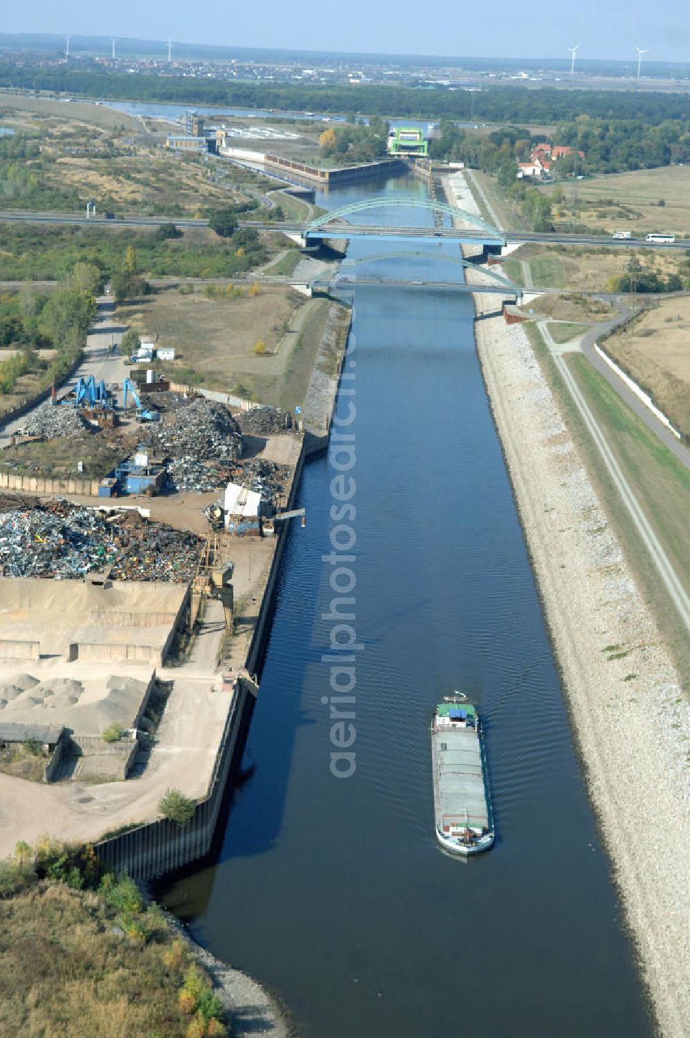 MAGDEBURG from above - Blick auf die Industriegebiete am Ufer des Elbe-Abstiegskanal, der den Magdeburger Binnen- Hafen mit der Schleuse Rothensee und dem Mittellandkanal verbindet: Dieser wird auf breiter Front derzeit ausgebaut. Die Bauvorhaben unterstützen die Bestrebungen der Magdeburger Hafengesellschaft, den größten Binnenhafen Mitteldeutschlands zu einer Drehscheibe des internationalen Schiffstransports zu machen. Kontakt WSV: Wasserstraßen-Neubauamt Magdeburg, 39106 Magdeburg, Tel. +49(0)391 535-0, email: wna-magdeburg@wsv.bund.de