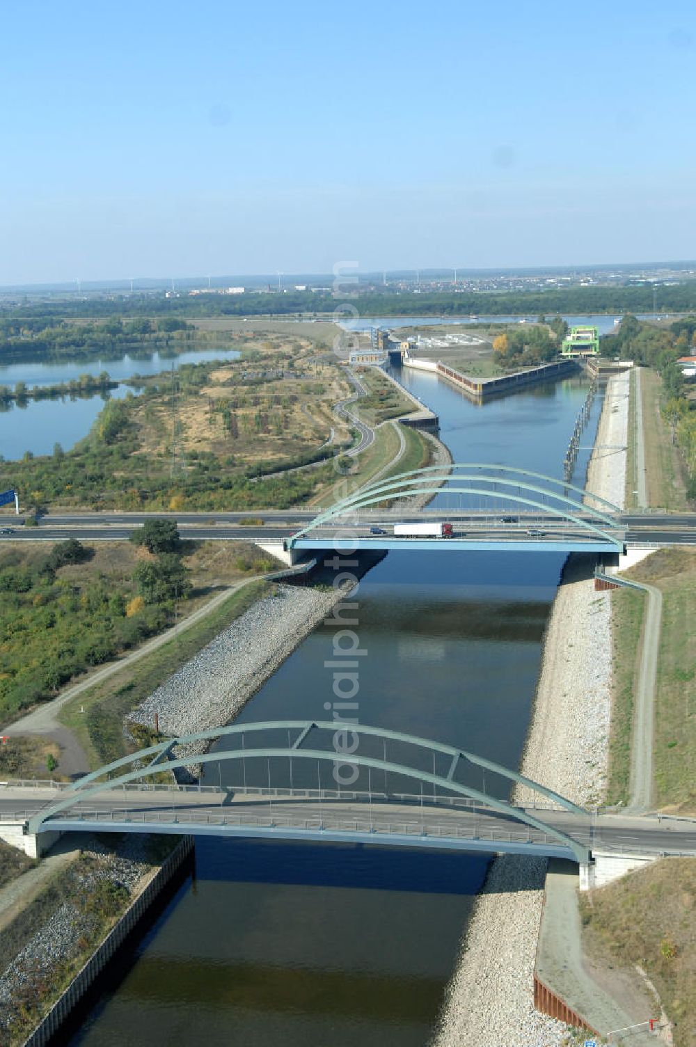 MAGDEBURG from the bird's eye view: Blick auf die Industriegebiete am Ufer des Elbe-Abstiegskanal, der den Magdeburger Binnen- Hafen mit der Schleuse Rothensee und dem Mittellandkanal verbindet: Dieser wird auf breiter Front derzeit ausgebaut. Die Bauvorhaben unterstützen die Bestrebungen der Magdeburger Hafengesellschaft, den größten Binnenhafen Mitteldeutschlands zu einer Drehscheibe des internationalen Schiffstransports zu machen. Kontakt WSV: Wasserstraßen-Neubauamt Magdeburg, 39106 Magdeburg, Tel. +49(0)391 535-0, email: wna-magdeburg@wsv.bund.de