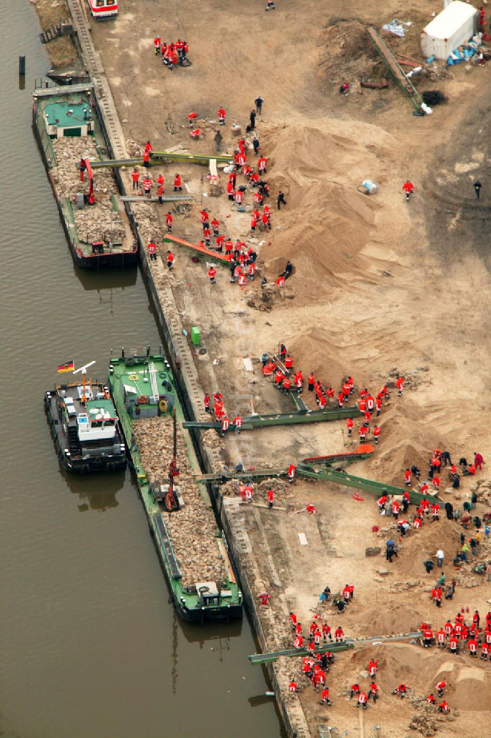 Aerial photograph Alt Garge - Blick auf den Hafen von Alt Garge wo Helfer / Rettungskräfte / Hilfskräfte Sandsäcke befüllen und diese per Fliesband auf Transportschiffe laden.