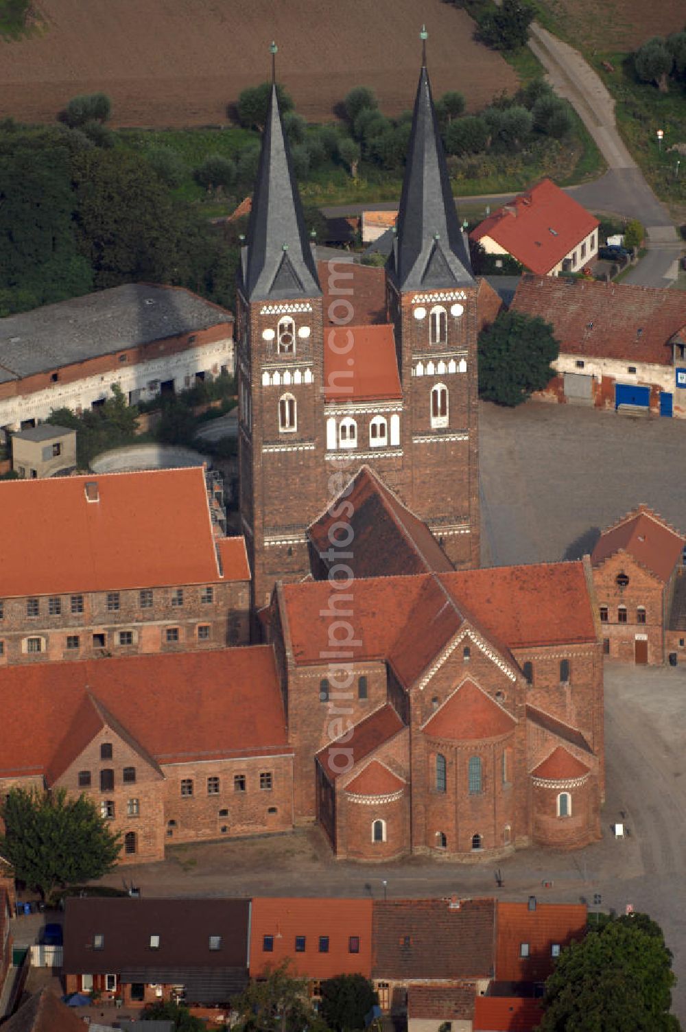 Jerichow from the bird's eye view: Blick auf die Klosterkirche und den Hof in Jerichow. Sie ist Teil der Strasse der Romanik in Sachsen-Anhalt. Diese verbindet die Dome, Burgen, Klöster und Kirchen die in der Zeit vom 10. bis Mitte des 13. Jahrhundert entstanden, und somit ein Zeichen der Christianisierung sind. Kontakt: Stiftung Kloster Jerichow, Am Kloster 1, D-39319 Jerichow; Telefon: (039343) 285 oder 92660; Telefax: (039343) 92661; eMail: nfo@stiftung-kloster-jerichow.de