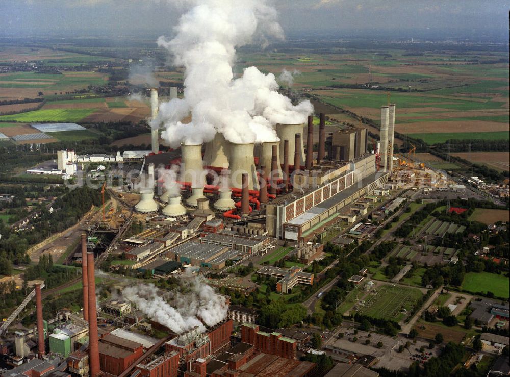 Aerial photograph NIEDERAUßEM - Blick auf das Ensemble der Kohle- Kraftwerk bei Neurath und Niederaußem in Nordrhein-Westfalen. Das Kraftwerk Niederaußem ist ein von der RWE Power mit Braunkohle betriebenes Grundlastkraftwerk in Bergheim-Niederaußem (Rhein-Erft-Kreis). Der Wind treibt die aus den Kühltürmen und Schloten austretenden Rauchfahnen kilometerweit in das Umland. RWE hat am Standort in Zusammenarbeit mit Linde und BASF eine Pilotanlage zur CO2-Abscheidung aufgebaut. Ensemble of the RWE coal power plant in Neurath and Niederaussem in North Rhine-Westphalia.