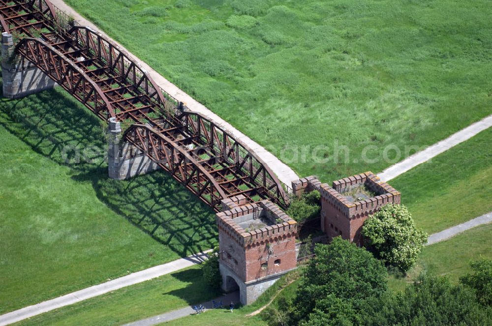 Dömitz from above - Ruine der Eisenbahnbrücke Dömitz, sie wurde in den Jahren 1870–1873 für die Wendlandbahn errichtet und bis zum Zweiten Weltkrieg befahren.An jedem Brückenende befand sich ein wehrhaft ausgebautes Brückenhaus. Starke Türme mit Zinnenkranz und Schießscharten standen beiderseits der Gleise. Im Erdgeschoss und Fundamentbereich lagen Gewölbe in kasemattenähnlicher Form. Der erste Spatenstich zum Bau der Brücke wurde am 08.09.1870 ausgeführt. Die Brücke hatte eine Gesamtlänge von 1.050 Metern. Nach ihrer Zerstörung am 20. April 1945 erfolgte kein Wiederaufbau, da die Elbe hier Teil der innerdeutschen Grenze war.