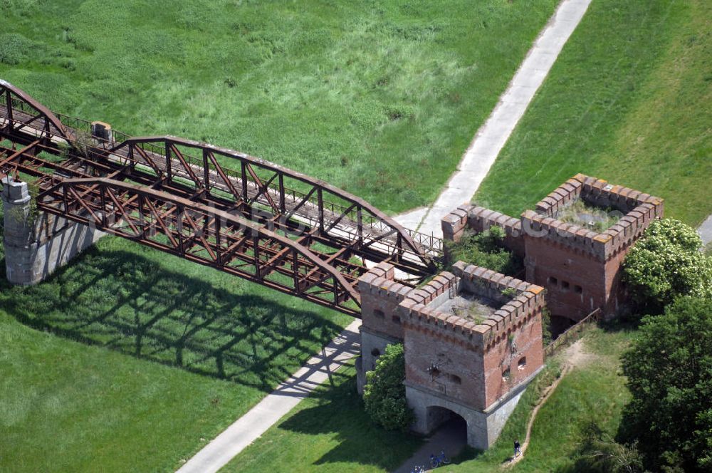 Dömitz from above - Ruine der Eisenbahnbrücke Dömitz, sie wurde in den Jahren 1870–1873 für die Wendlandbahn errichtet und bis zum Zweiten Weltkrieg befahren.An jedem Brückenende befand sich ein wehrhaft ausgebautes Brückenhaus. Starke Türme mit Zinnenkranz und Schießscharten standen beiderseits der Gleise. Im Erdgeschoss und Fundamentbereich lagen Gewölbe in kasemattenähnlicher Form. Der erste Spatenstich zum Bau der Brücke wurde am 08.09.1870 ausgeführt. Die Brücke hatte eine Gesamtlänge von 1.050 Metern. Nach ihrer Zerstörung am 20. April 1945 erfolgte kein Wiederaufbau, da die Elbe hier Teil der innerdeutschen Grenze war.