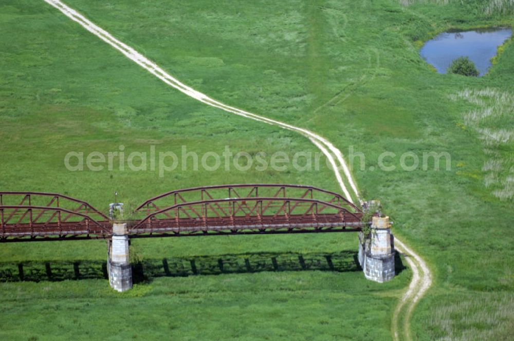 Dömitz from the bird's eye view: Ruine der Eisenbahnbrücke Dömitz, sie wurde in den Jahren 1870–1873 für die Wendlandbahn errichtet und bis zum Zweiten Weltkrieg befahren.An jedem Brückenende befand sich ein wehrhaft ausgebautes Brückenhaus. Starke Türme mit Zinnenkranz und Schießscharten standen beiderseits der Gleise. Im Erdgeschoss und Fundamentbereich lagen Gewölbe in kasemattenähnlicher Form. Der erste Spatenstich zum Bau der Brücke wurde am 08.09.1870 ausgeführt. Die Brücke hatte eine Gesamtlänge von 1.050 Metern. Nach ihrer Zerstörung am 20. April 1945 erfolgte kein Wiederaufbau, da die Elbe hier Teil der innerdeutschen Grenze war.