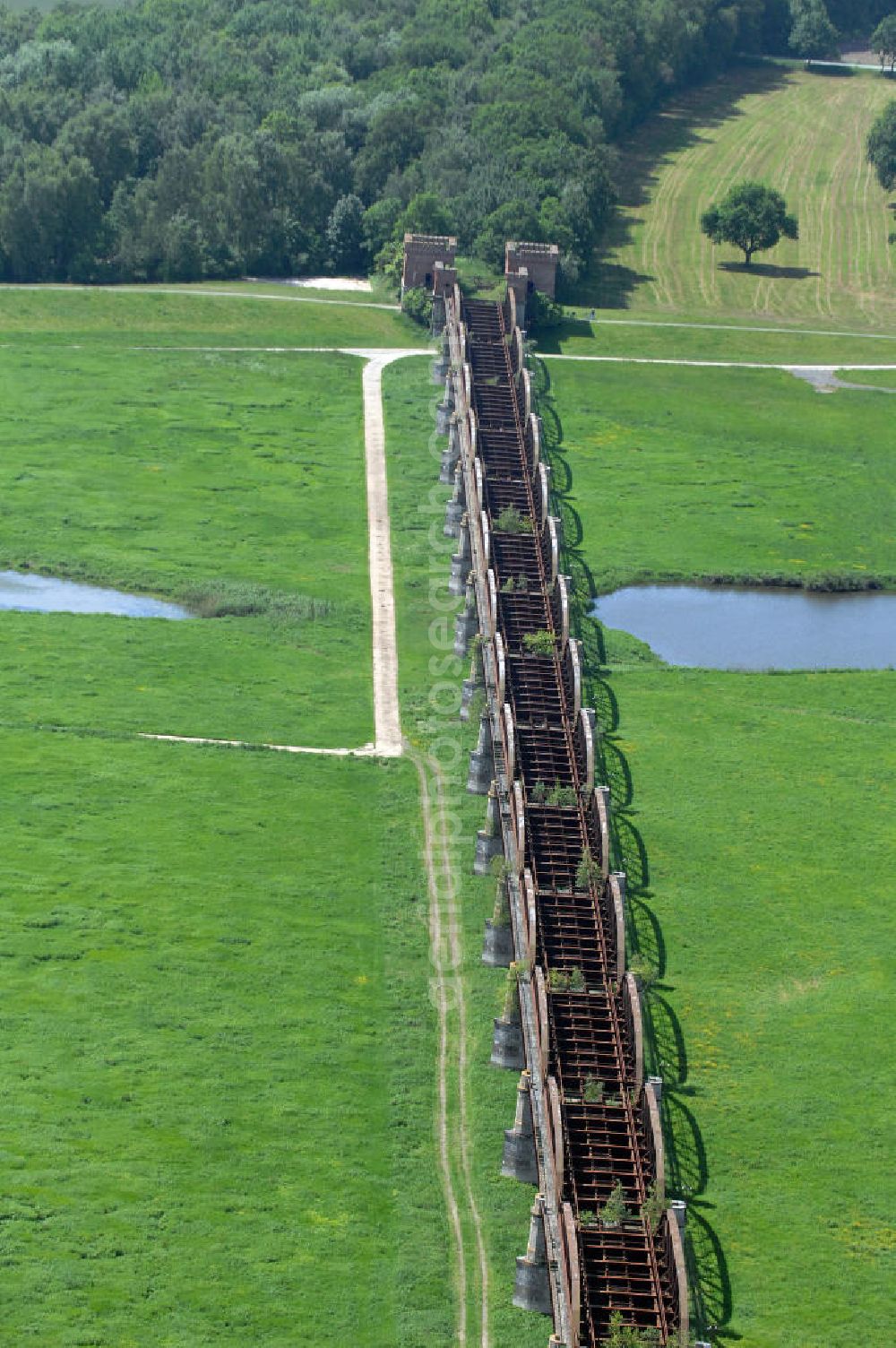 Dömitz from above - Ruine der Eisenbahnbrücke Dömitz, sie wurde in den Jahren 1870–1873 für die Wendlandbahn errichtet und bis zum Zweiten Weltkrieg befahren.An jedem Brückenende befand sich ein wehrhaft ausgebautes Brückenhaus. Starke Türme mit Zinnenkranz und Schießscharten standen beiderseits der Gleise. Im Erdgeschoss und Fundamentbereich lagen Gewölbe in kasemattenähnlicher Form. Der erste Spatenstich zum Bau der Brücke wurde am 08.09.1870 ausgeführt. Die Brücke hatte eine Gesamtlänge von 1.050 Metern. Nach ihrer Zerstörung am 20. April 1945 erfolgte kein Wiederaufbau, da die Elbe hier Teil der innerdeutschen Grenze war.