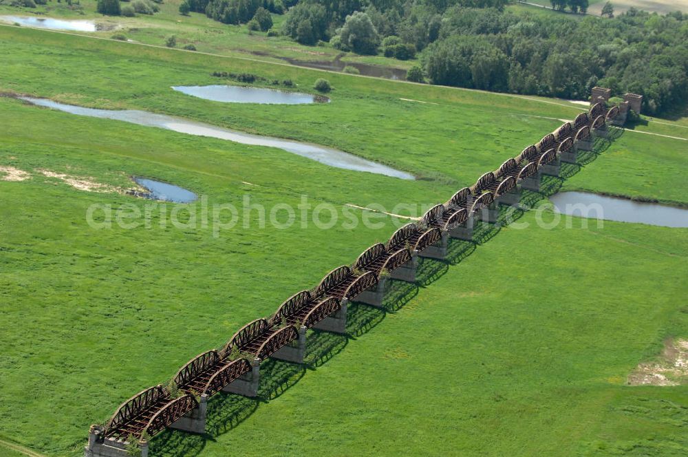 Dömitz from the bird's eye view: Ruine der Eisenbahnbrücke Dömitz, sie wurde in den Jahren 1870–1873 für die Wendlandbahn errichtet und bis zum Zweiten Weltkrieg befahren.An jedem Brückenende befand sich ein wehrhaft ausgebautes Brückenhaus. Starke Türme mit Zinnenkranz und Schießscharten standen beiderseits der Gleise. Im Erdgeschoss und Fundamentbereich lagen Gewölbe in kasemattenähnlicher Form. Der erste Spatenstich zum Bau der Brücke wurde am 08.09.1870 ausgeführt. Die Brücke hatte eine Gesamtlänge von 1.050 Metern. Nach ihrer Zerstörung am 20. April 1945 erfolgte kein Wiederaufbau, da die Elbe hier Teil der innerdeutschen Grenze war.