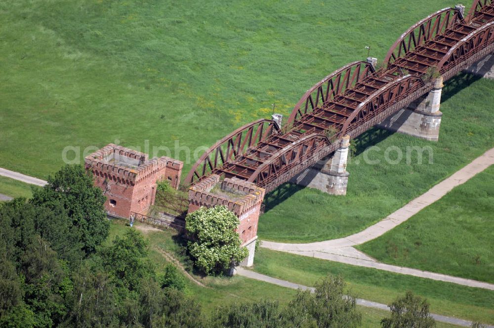 Dömitz from above - Ruine der Eisenbahnbrücke Dömitz, sie wurde in den Jahren 1870–1873 für die Wendlandbahn errichtet und bis zum Zweiten Weltkrieg befahren.An jedem Brückenende befand sich ein wehrhaft ausgebautes Brückenhaus. Starke Türme mit Zinnenkranz und Schießscharten standen beiderseits der Gleise. Im Erdgeschoss und Fundamentbereich lagen Gewölbe in kasemattenähnlicher Form. Der erste Spatenstich zum Bau der Brücke wurde am 08.09.1870 ausgeführt. Die Brücke hatte eine Gesamtlänge von 1.050 Metern. Nach ihrer Zerstörung am 20. April 1945 erfolgte kein Wiederaufbau, da die Elbe hier Teil der innerdeutschen Grenze war.