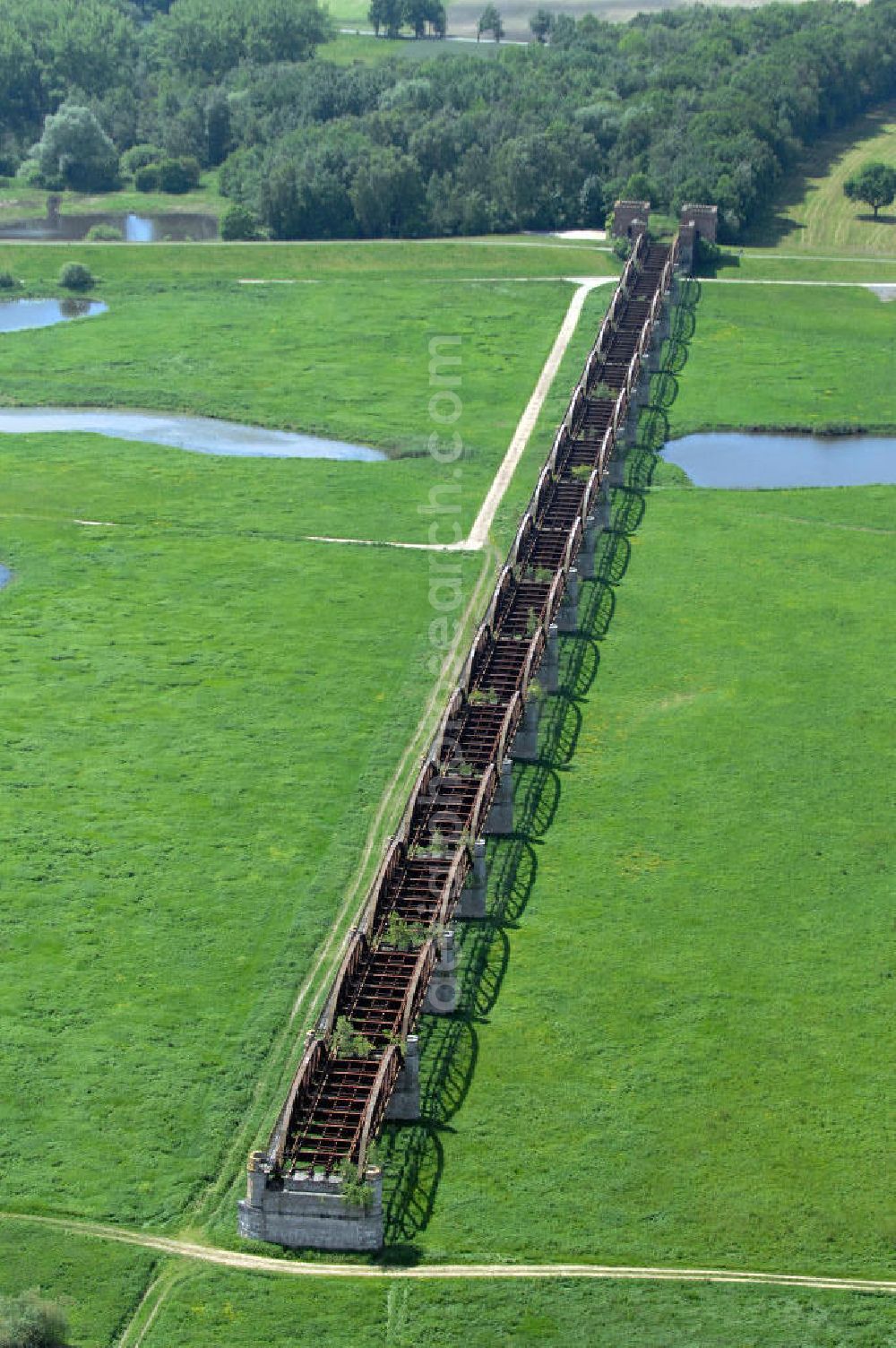 Dömitz from the bird's eye view: Ruine der Eisenbahnbrücke Dömitz, sie wurde in den Jahren 1870–1873 für die Wendlandbahn errichtet und bis zum Zweiten Weltkrieg befahren.An jedem Brückenende befand sich ein wehrhaft ausgebautes Brückenhaus. Starke Türme mit Zinnenkranz und Schießscharten standen beiderseits der Gleise. Im Erdgeschoss und Fundamentbereich lagen Gewölbe in kasemattenähnlicher Form. Der erste Spatenstich zum Bau der Brücke wurde am 08.09.1870 ausgeführt. Die Brücke hatte eine Gesamtlänge von 1.050 Metern. Nach ihrer Zerstörung am 20. April 1945 erfolgte kein Wiederaufbau, da die Elbe hier Teil der innerdeutschen Grenze war.