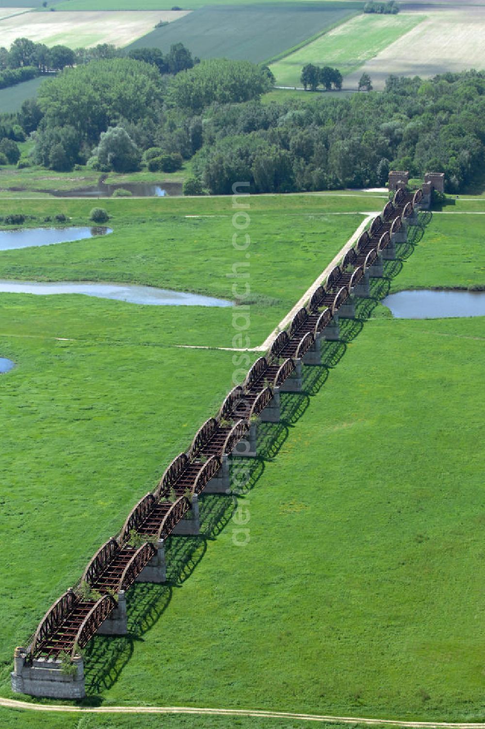 Aerial image Dömitz - Ruine der Eisenbahnbrücke Dömitz, sie wurde in den Jahren 1870–1873 für die Wendlandbahn errichtet und bis zum Zweiten Weltkrieg befahren.An jedem Brückenende befand sich ein wehrhaft ausgebautes Brückenhaus. Starke Türme mit Zinnenkranz und Schießscharten standen beiderseits der Gleise. Im Erdgeschoss und Fundamentbereich lagen Gewölbe in kasemattenähnlicher Form. Der erste Spatenstich zum Bau der Brücke wurde am 08.09.1870 ausgeführt. Die Brücke hatte eine Gesamtlänge von 1.050 Metern. Nach ihrer Zerstörung am 20. April 1945 erfolgte kein Wiederaufbau, da die Elbe hier Teil der innerdeutschen Grenze war.