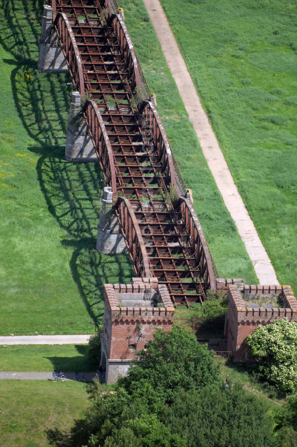 Dömitz from the bird's eye view: Ruine der Eisenbahnbrücke Dömitz, sie wurde in den Jahren 1870–1873 für die Wendlandbahn errichtet und bis zum Zweiten Weltkrieg befahren.An jedem Brückenende befand sich ein wehrhaft ausgebautes Brückenhaus. Starke Türme mit Zinnenkranz und Schießscharten standen beiderseits der Gleise. Im Erdgeschoss und Fundamentbereich lagen Gewölbe in kasemattenähnlicher Form. Der erste Spatenstich zum Bau der Brücke wurde am 08.09.1870 ausgeführt. Die Brücke hatte eine Gesamtlänge von 1.050 Metern. Nach ihrer Zerstörung am 20. April 1945 erfolgte kein Wiederaufbau, da die Elbe hier Teil der innerdeutschen Grenze war.